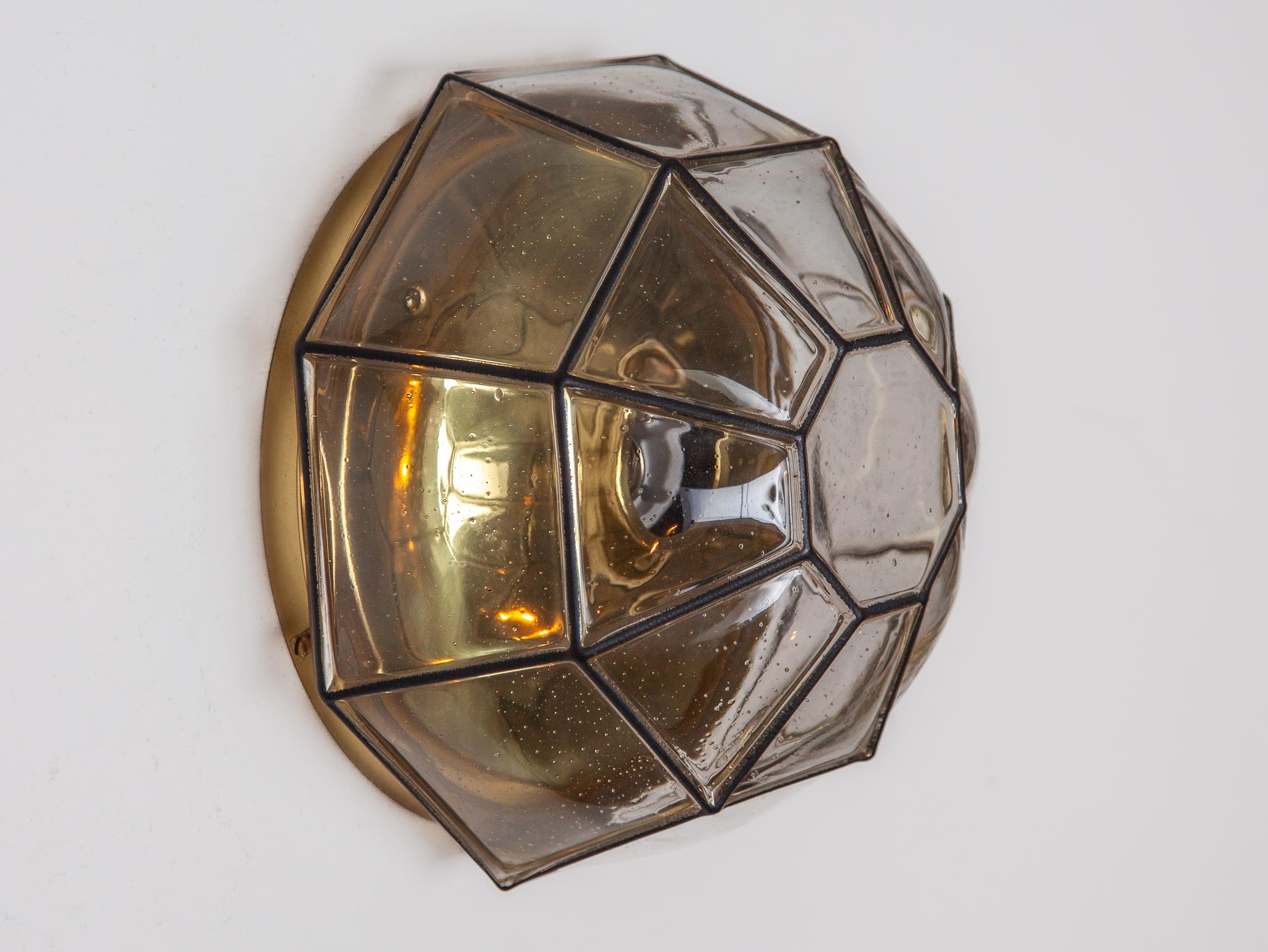 Beautiful wall lights with a unique 'iron' design by Glashütte Limburg, Germany. Manufactured in Midcentury, circa 1970. Black 'iron' squares inlaid in thick clear glass. High quality and in very good condition. Cleaned, well-wired and ready to use.