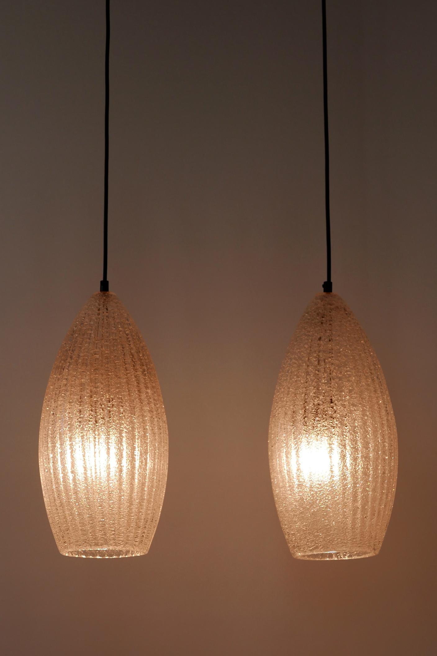 Set of two rare and elegant Mid-Century Modern pendant lamps. Manufactured probably in 1960s in Germany.

Executed in thick textured ice glass, each lamp comes with 1 x E27 / E26 Edison screw fit bulb holder, is rewired and in working condition.