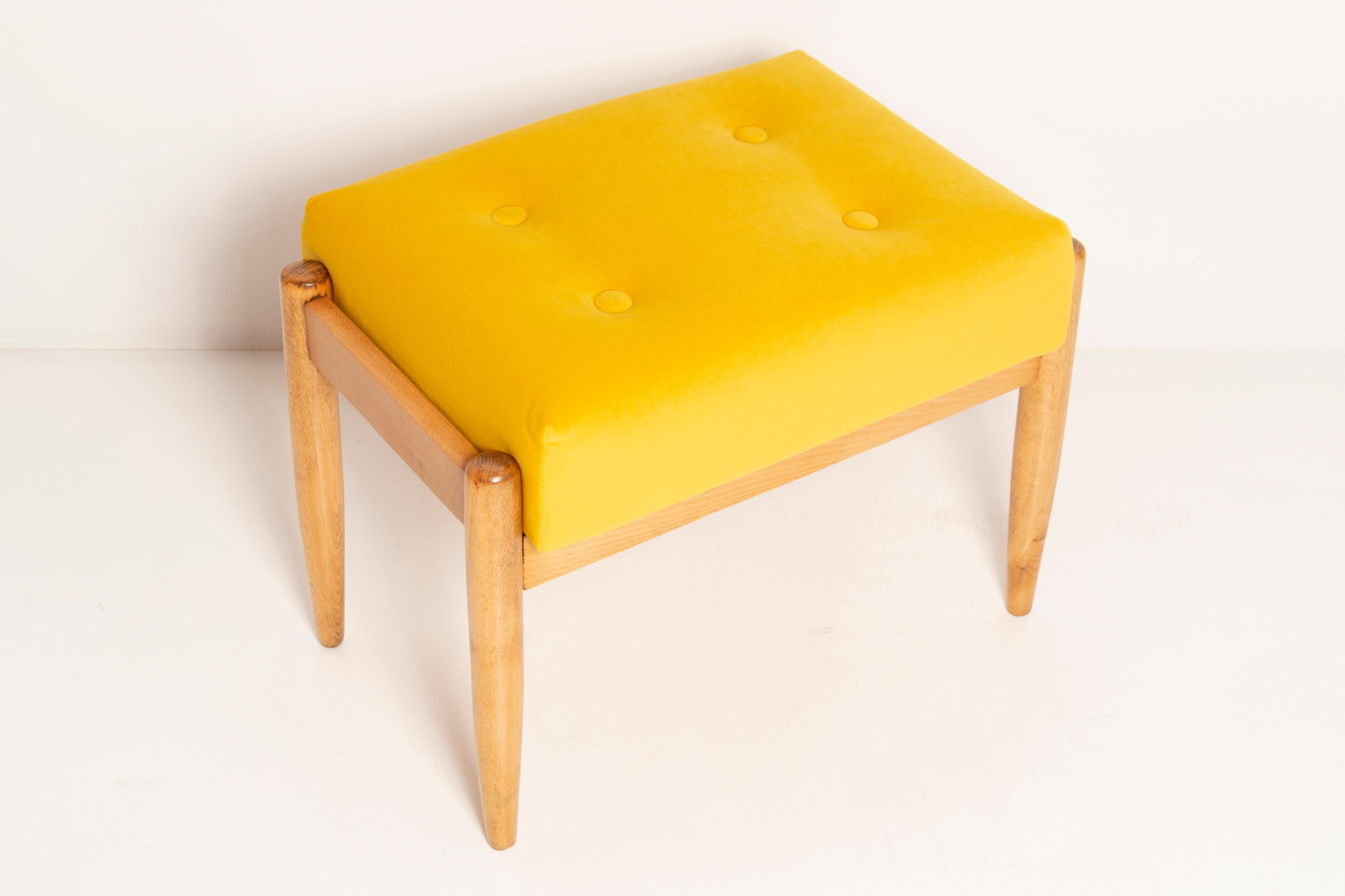 Stool from the turn of the 1960s. Beautiful mustard yellow high quality velvet upholstery. The stool consists of an upholstered part, a seat and wooden legs narrowing downwards, characteristic of the 1960s style. We can prepare this stool also in