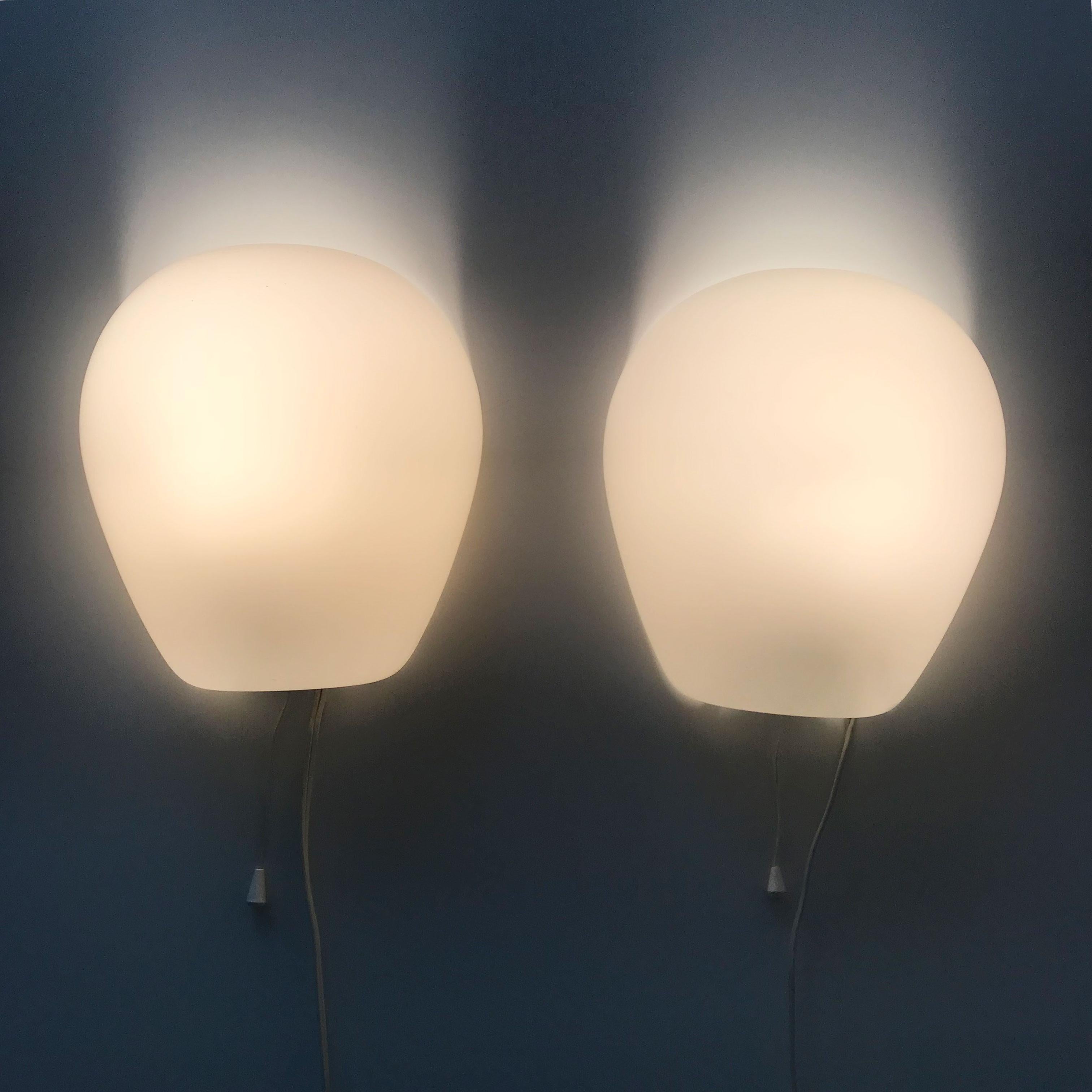 Set of two elegant Mid-Century Modern wall lamps or sconces 'wall shell 2681'. Designed by the famous German Designer Wilhelm Wagenfeld in 1952. Manufactured by Peill & Putzler in 1950s, Germany.

These elegant wall lamps are executed in shell