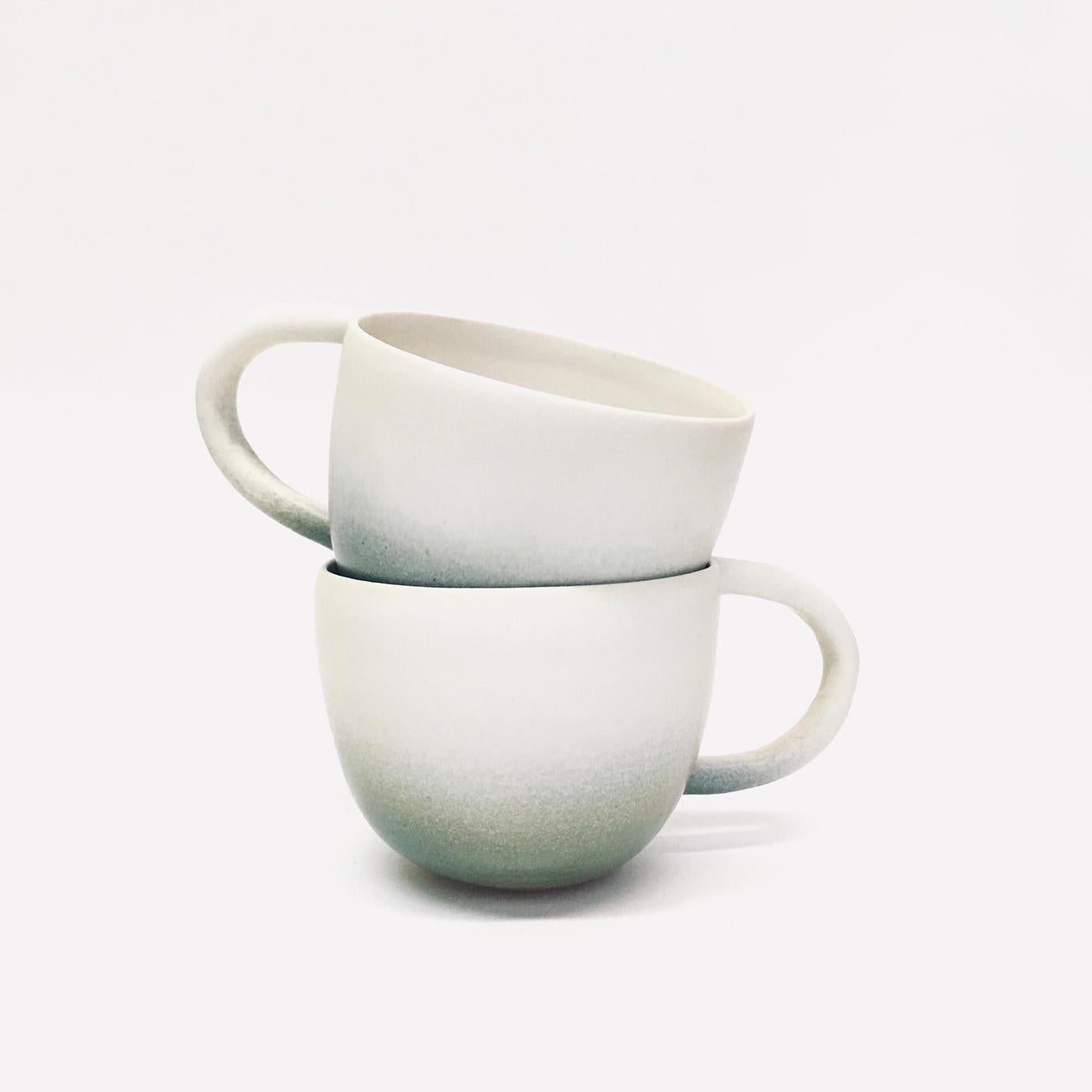 Set of two white stoneware mugs with a milk white satin glaze with a slate finish.

Each mug approximately 6” x 4.25” x 3.5”

Carol Joo Lee is an artist who loves working with clay and chasing that perfect glaze moment. 


