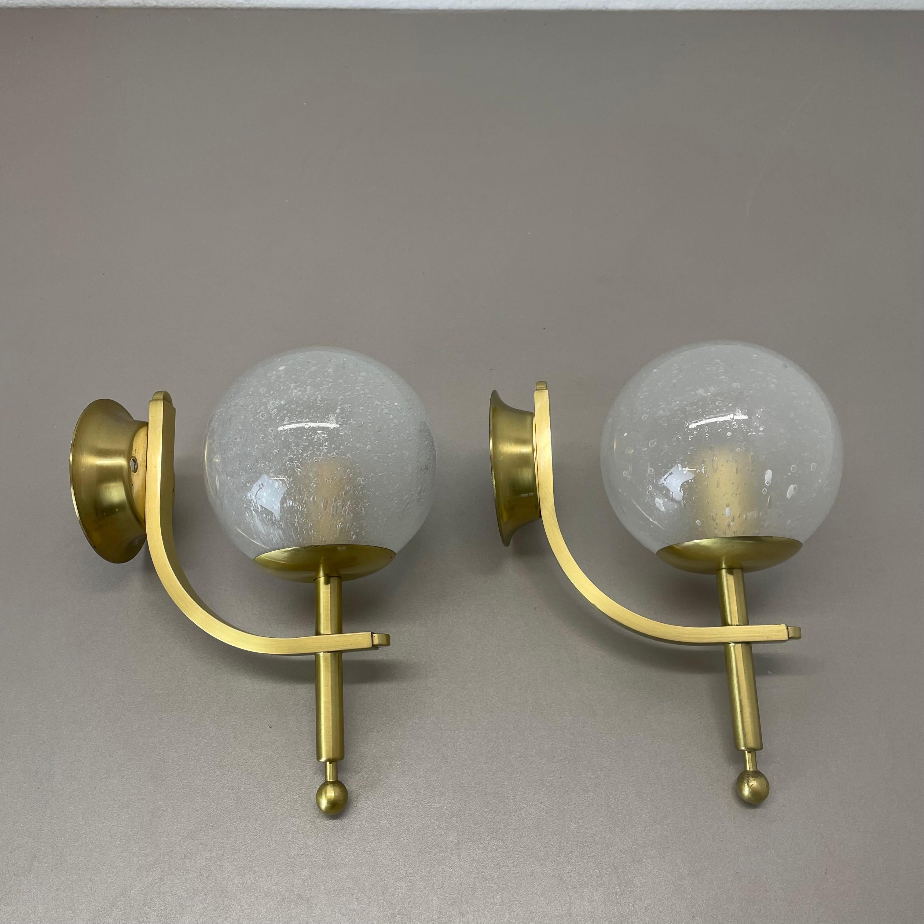 Article:

Set of two

Wall lights


Origin:

Italy



Age:

1970s




This set of two modernist wall lights was produced in Italy in the 1970s. It is made from solid brass with a frosted glass shade in ball form on the top. due to the shade the