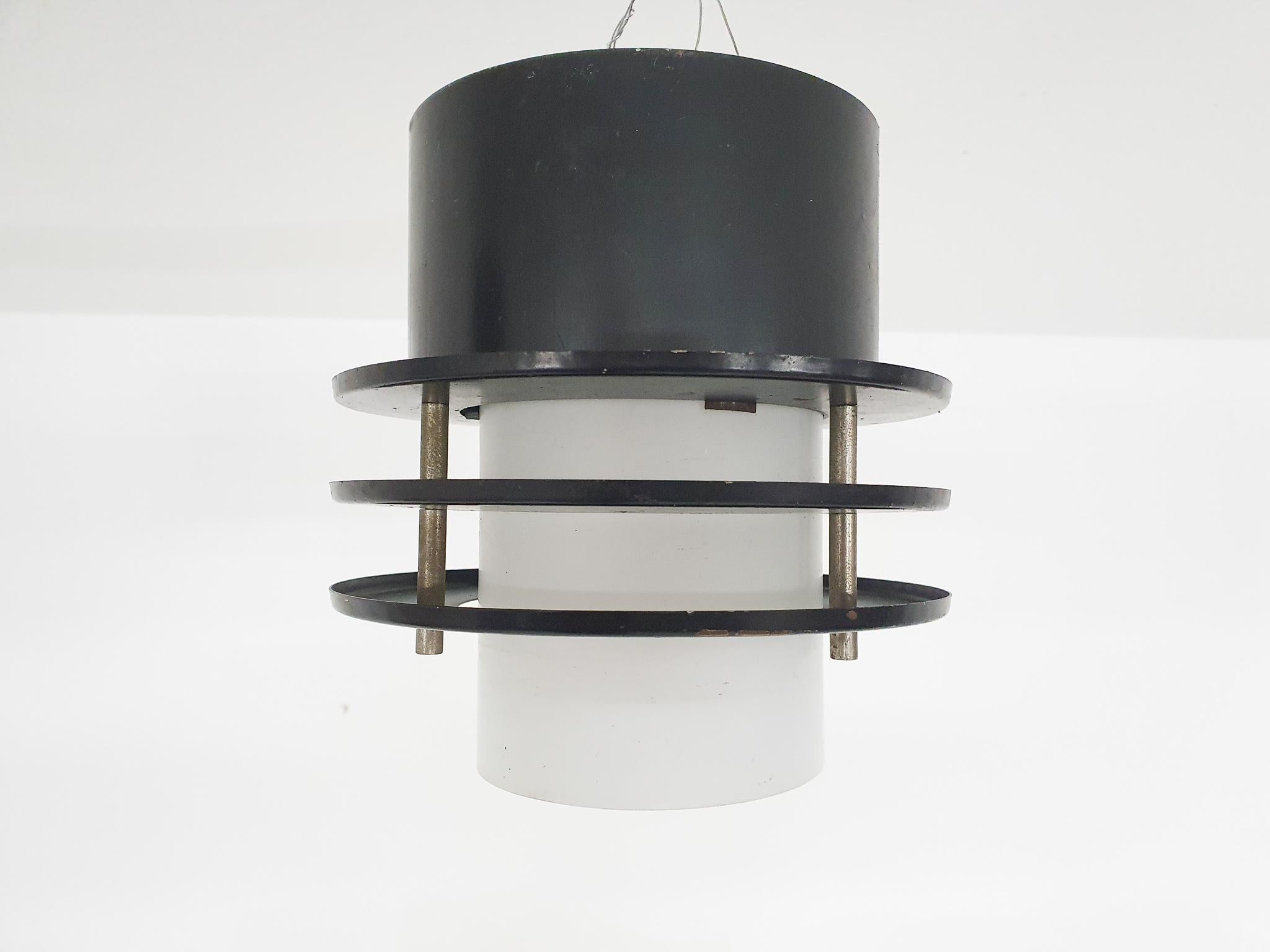 Set of two minimalistic ceiling lights, The Netherlands 1960s.

Black metal ceiling lights with white milk glass inside.