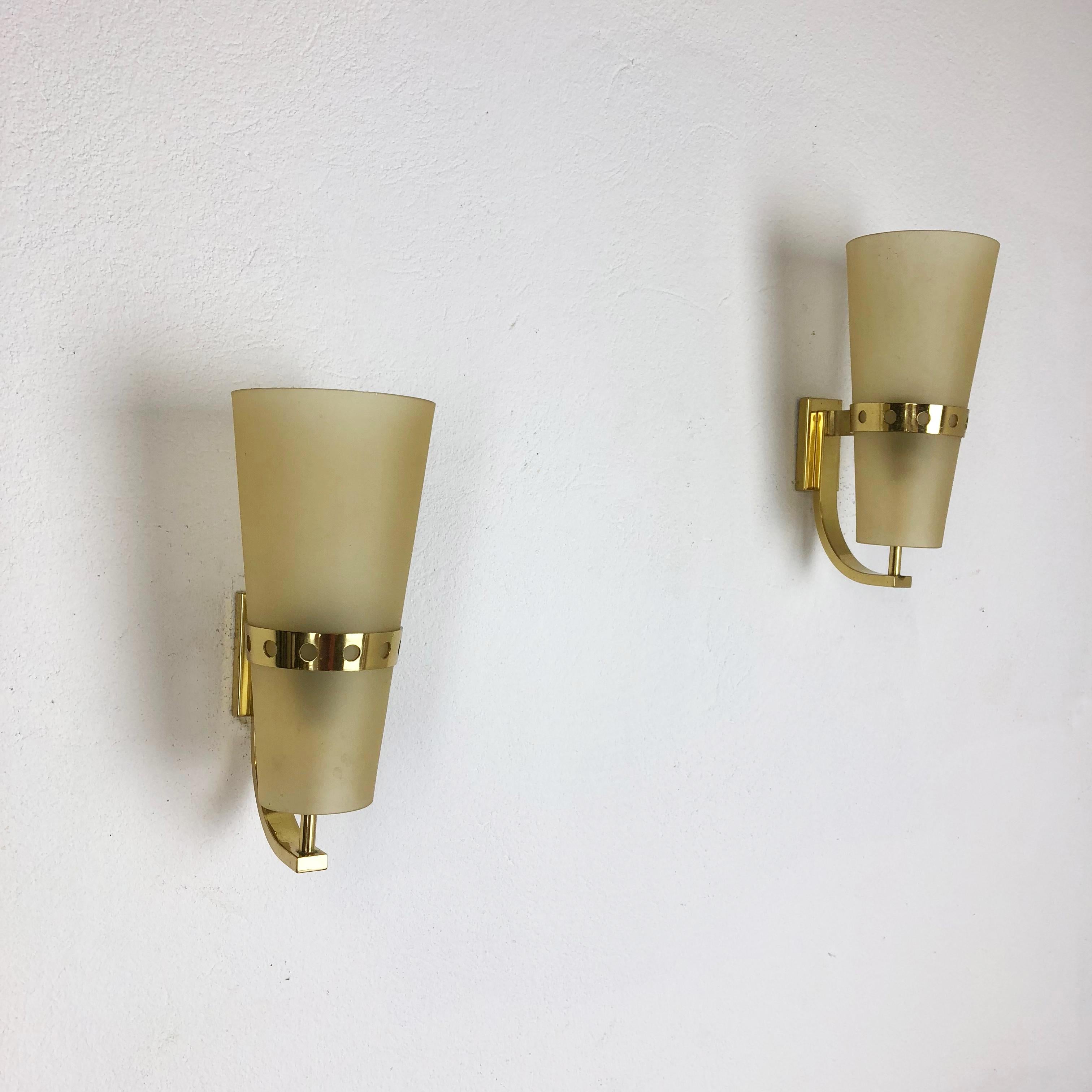 Article:

Set of two

Wall light scones


Origin:

Italy



Age:

1950s



This set of two modernist lights was produced in Italy in the 1950s. It is made from solid brass metal and has a lovely formed yellow satin shade. The