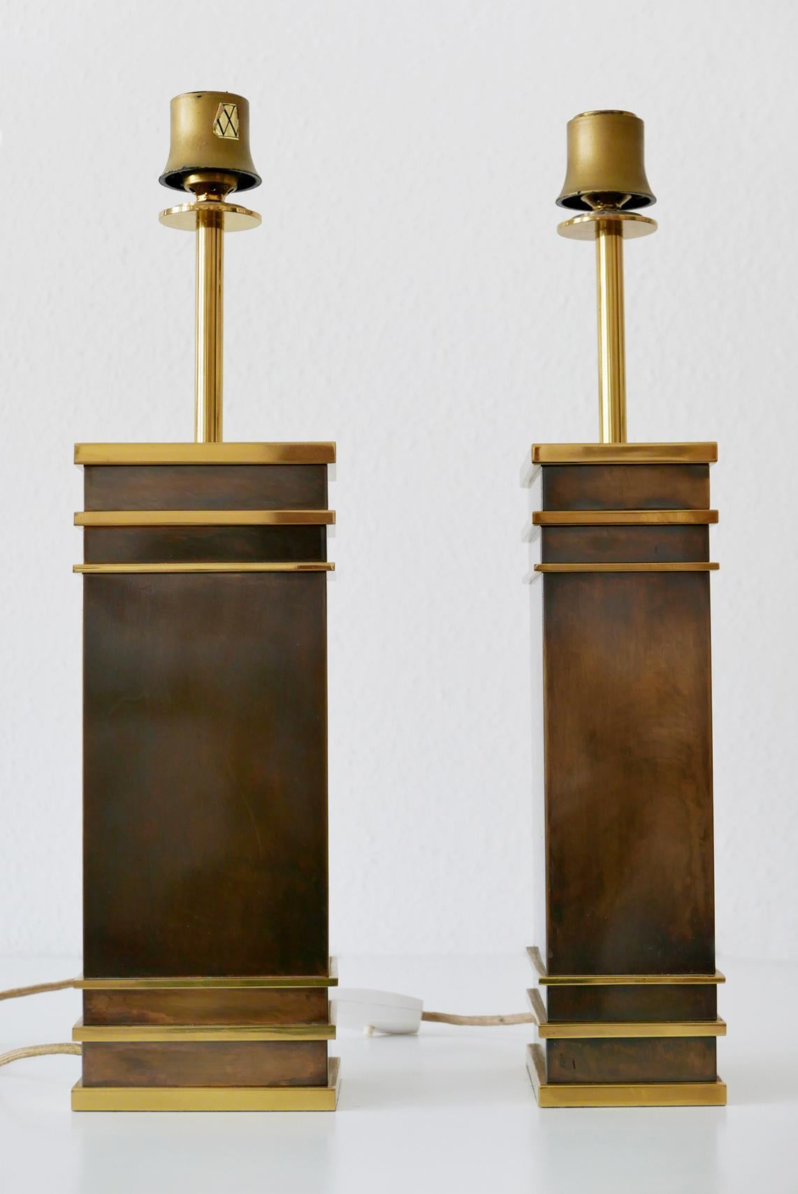 Satz von zwei monumentalen und äußerst seltenen Mid-Century Modern Tischlampen aus schwerem, massivem Messing. Entworfen und hergestellt von den Vereinigten Werkstätten, 1960er Jahre, Deutschland. Eine Lampe mit Herstellermarke.

Diese skulpturalen