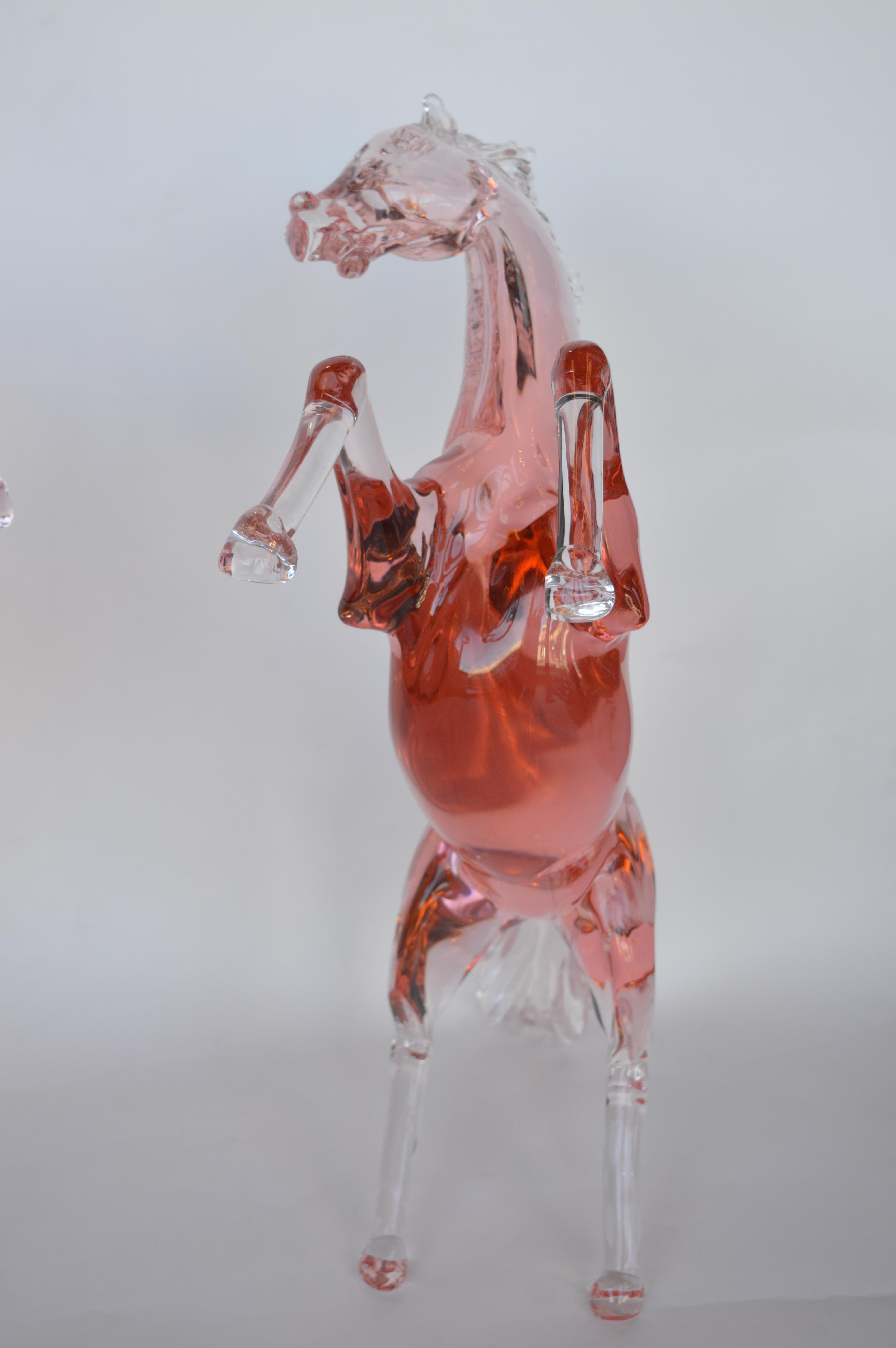 Two Murano rose colored horses. Signed Pino Signoretto, signature on the inner thigh. They are not an exact pair, one of the horses height is 23 inches.