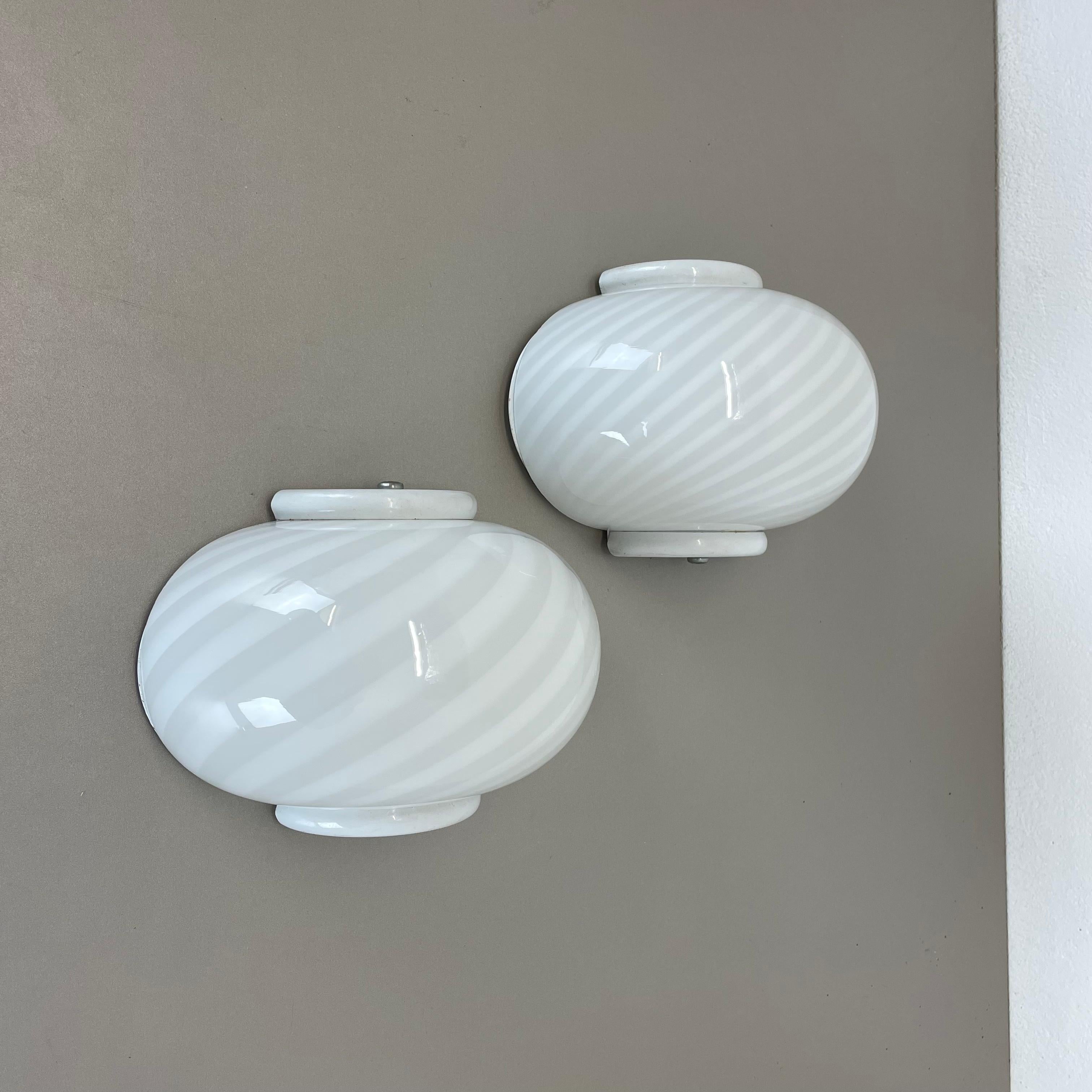 Article:

Set of two

Wall light sconces


Origin:

Italy


Producer:

Murano Vetri, Italy



Age:

1980s



This set of two modernist lights was produced in Italy in the 1980s. It is made from italian murano glass and has a
