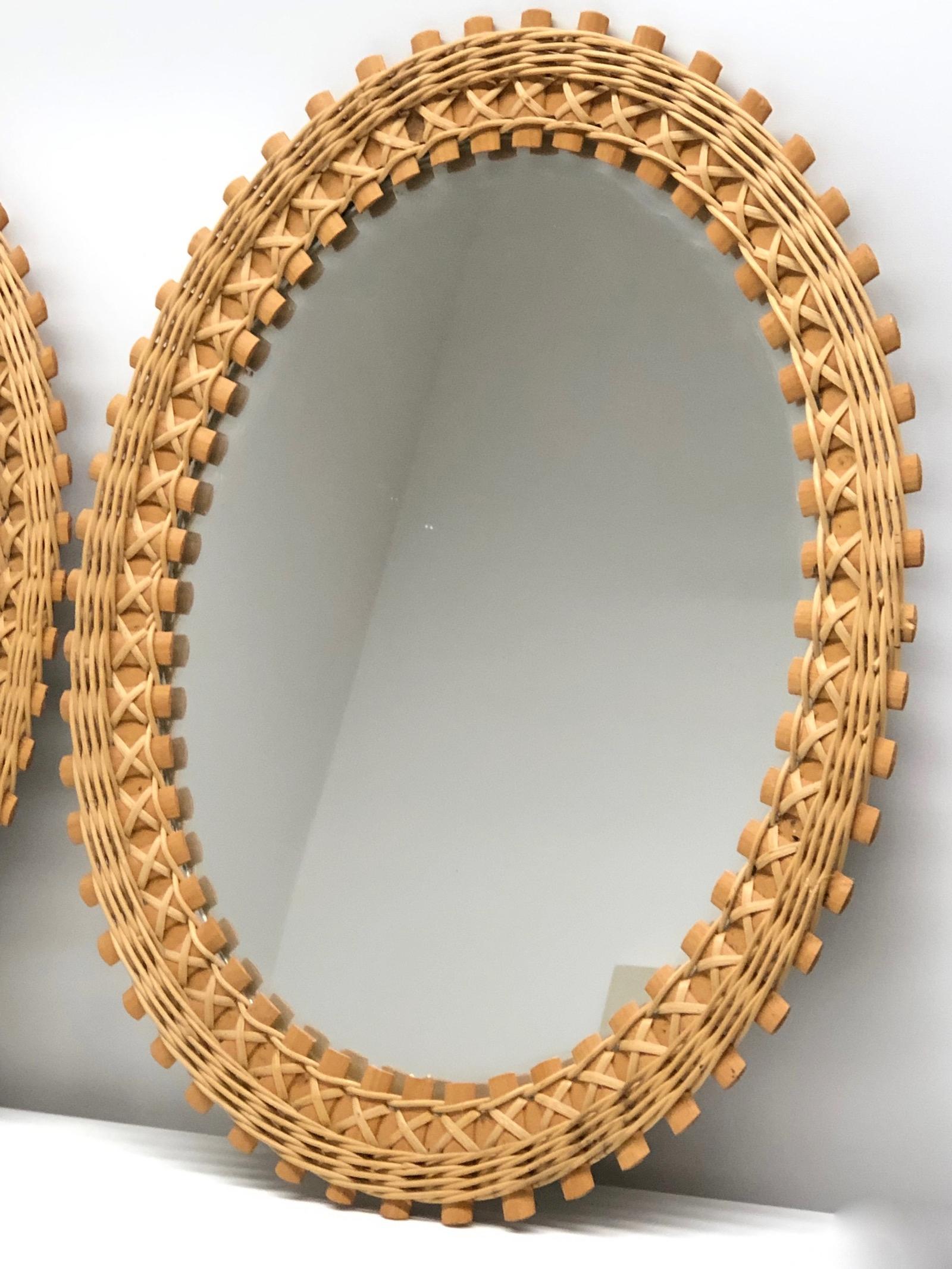 A beautiful pair or set of two hand woven oval shaped rattan and wicker mirror. These mirrors were made in a sheltered workshop, Germany, 1960s. Each one is marked with original Label, its very hard to find a matching pair of these mirrors.