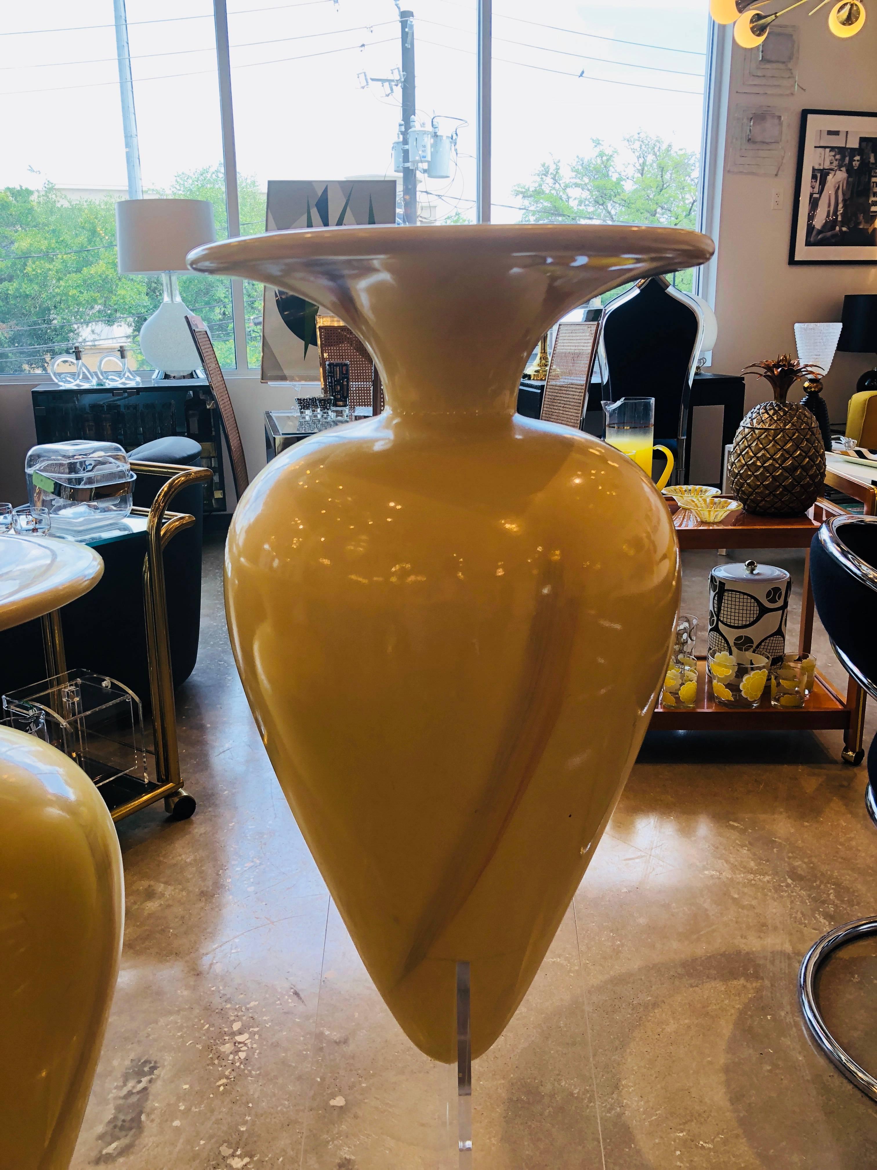Offered are two matching late 20th century, 1980s-1990s oversized decorative fiberglass floor urns on Lucite bases. The modern however elegant have a buttercream base color with light broad brushstrokes of light pink and light blue. Both urns sit