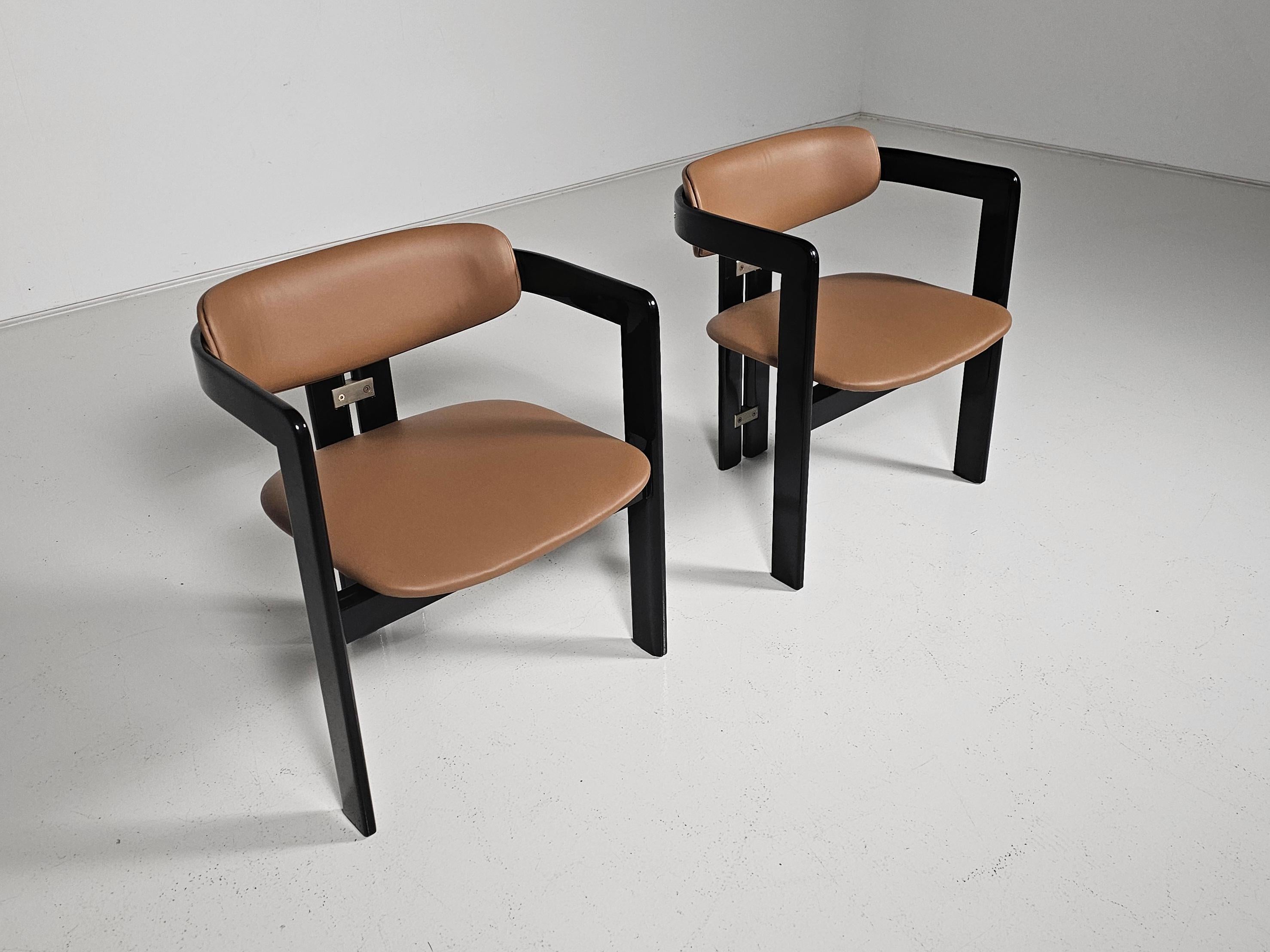 Augusto Savini per Pozzi, sedie da pranzo 'Pamplona', legno di frassino laccato nero, imbottitura in pelle color caramello, Italia, anni '60, set di 2.

Poltrone in legno nero e nuovi rivestimenti in pelle. Un design caratteristico, semplicistico ma