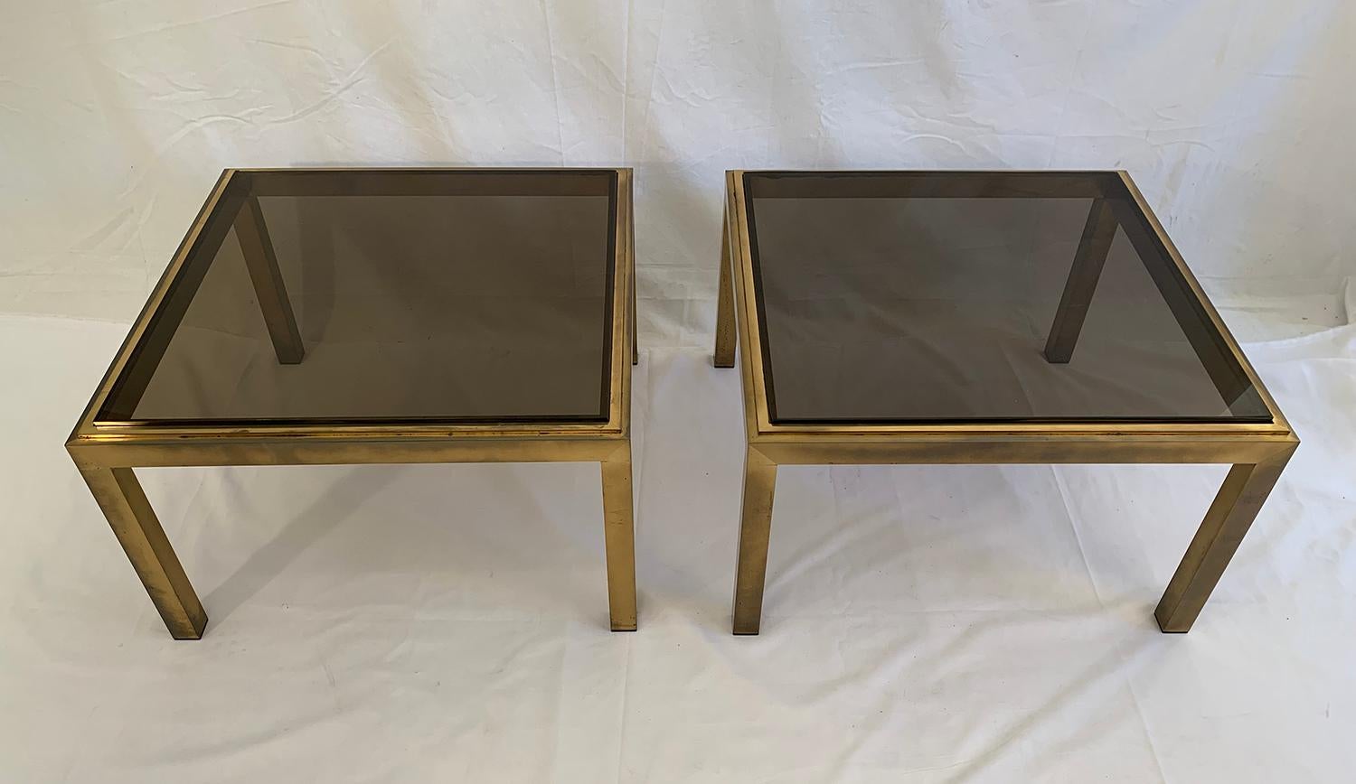 Beautiful set of brushed brass end tables, topped with a polished brass frame and a smoked glass top. The brass is very nicely patinated and the pair dates from the 1970s.

The glass can be replaced for 200 Euros

Magnifique ensemble de bouts de