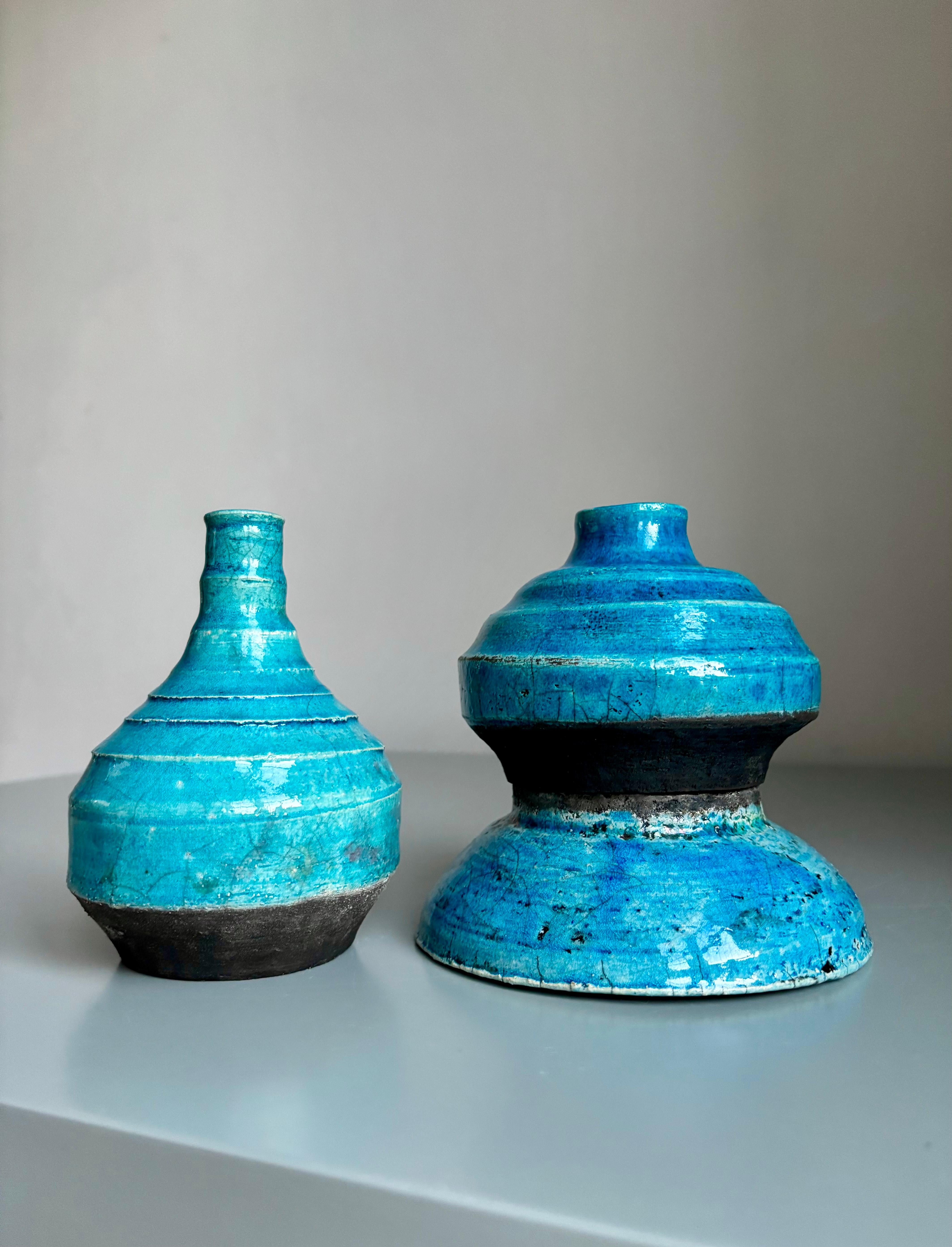 Two organic modern turquoise glazed vases that can double as candle holders. Shiny blue crackle glaze over anthracite clay. One item can be used upside down with the slender neck as base and the larger bowl on top. 
One vase stamped by artist.