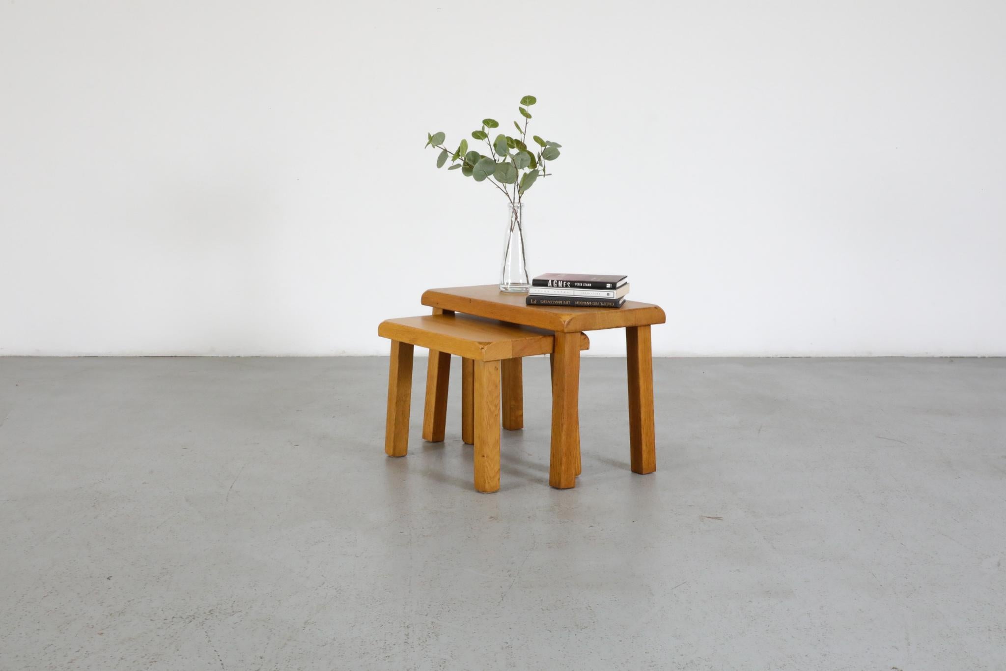 Set of two blonde oak nesting tables with rounded edges and square legs. The smaller table fits perfectly under the larger table. These can also be used as little foot stools, yet not recommended for holding full adult weight. Lightly refinished,