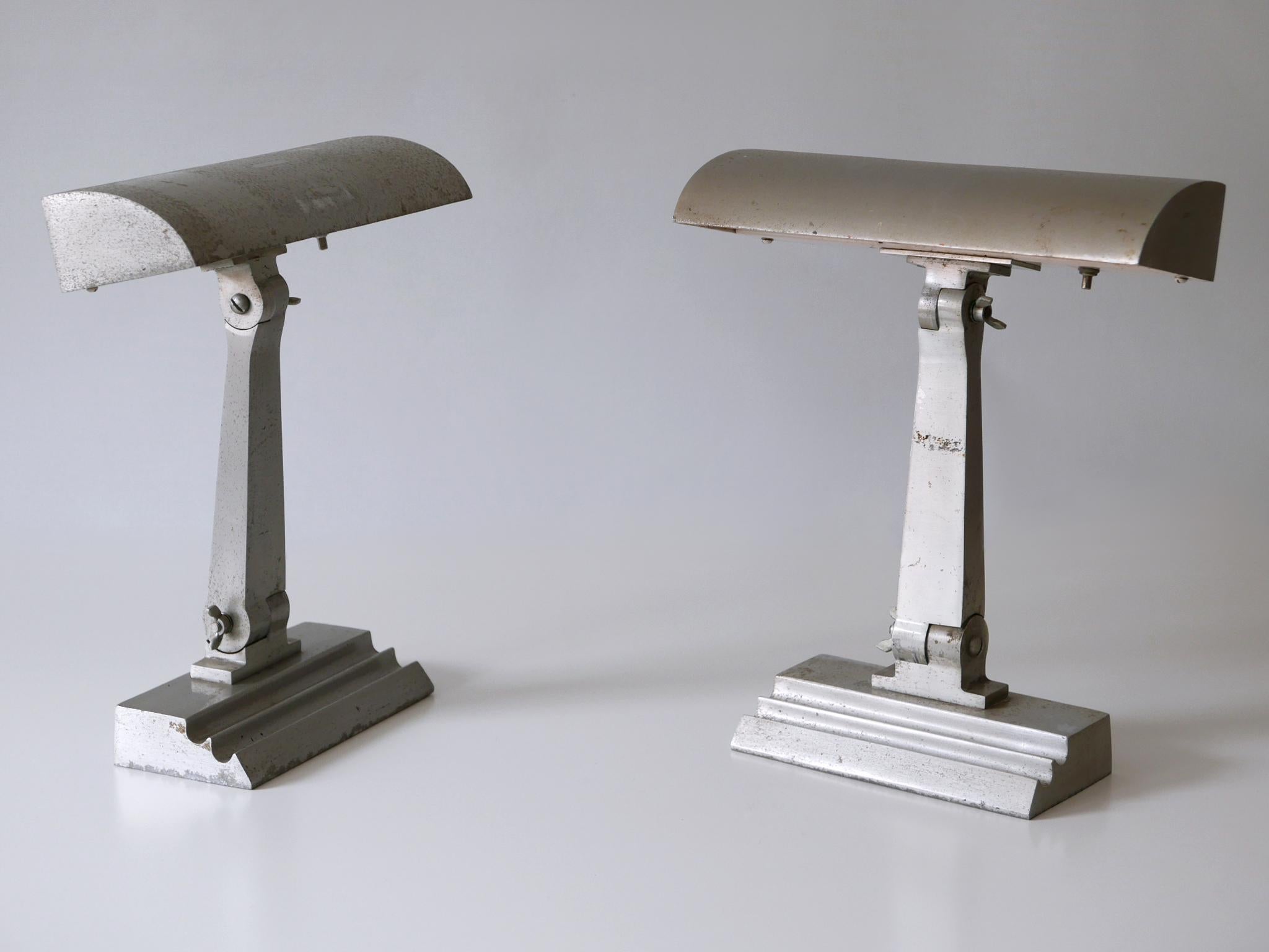 Set of two rare and elegant Art Deco cast aluminium desk or table lamps from an US cruiser ship. Arm and diffuser adjustable. Manufactured in USA, 1920s.

Attention please:
These lamps had been fixed by four screws directly to the desk or table to