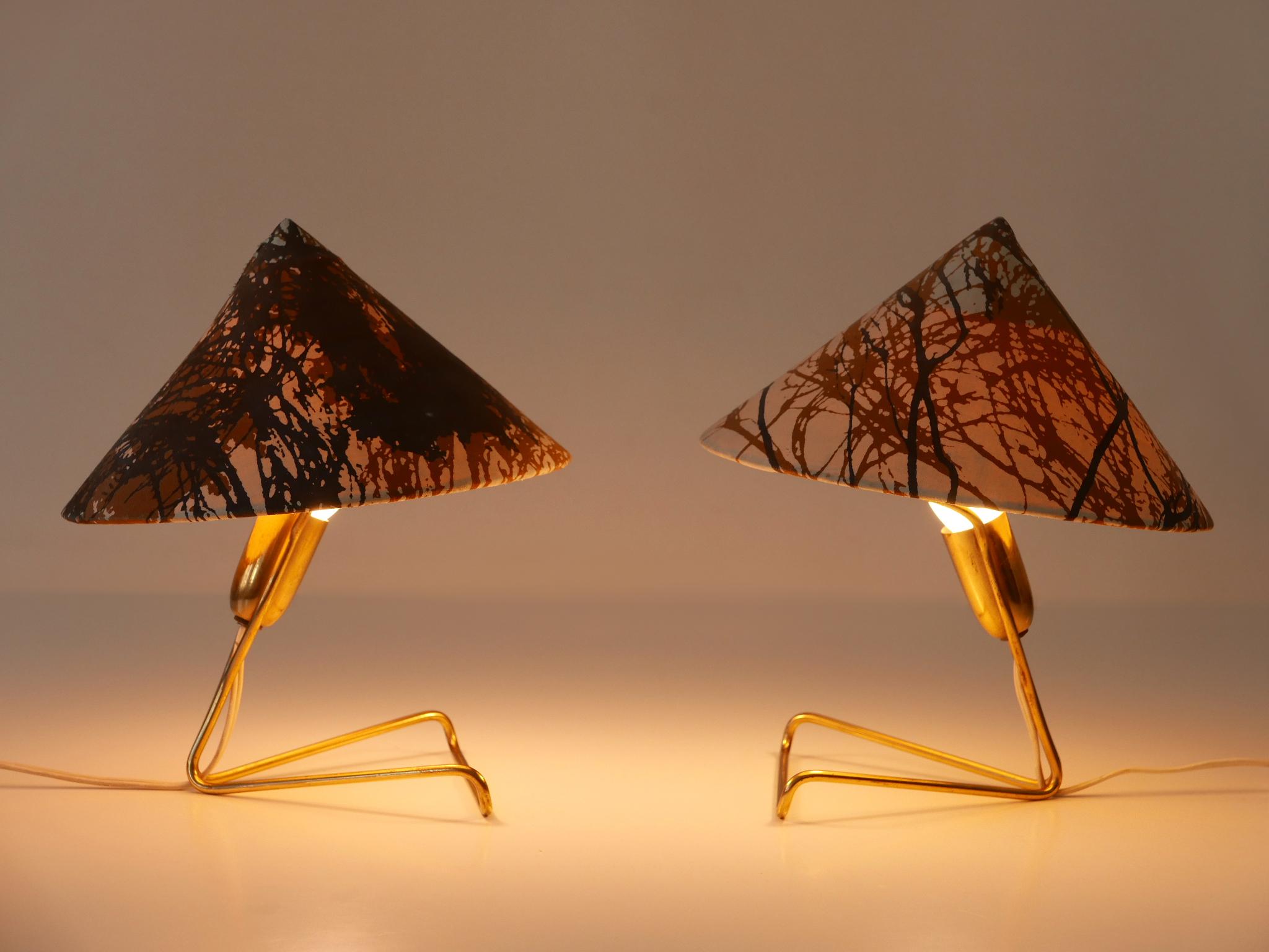 Ensemble de deux lampes de chevet / appliques en forme d'anguille, extrêmement rares et ravissantes, datant du milieu du siècle dernier. Fabriqué par Rupert Nikoll, Autriche 1952.

Exécutée en laiton et en tissu, chaque lampe est livrée avec un
