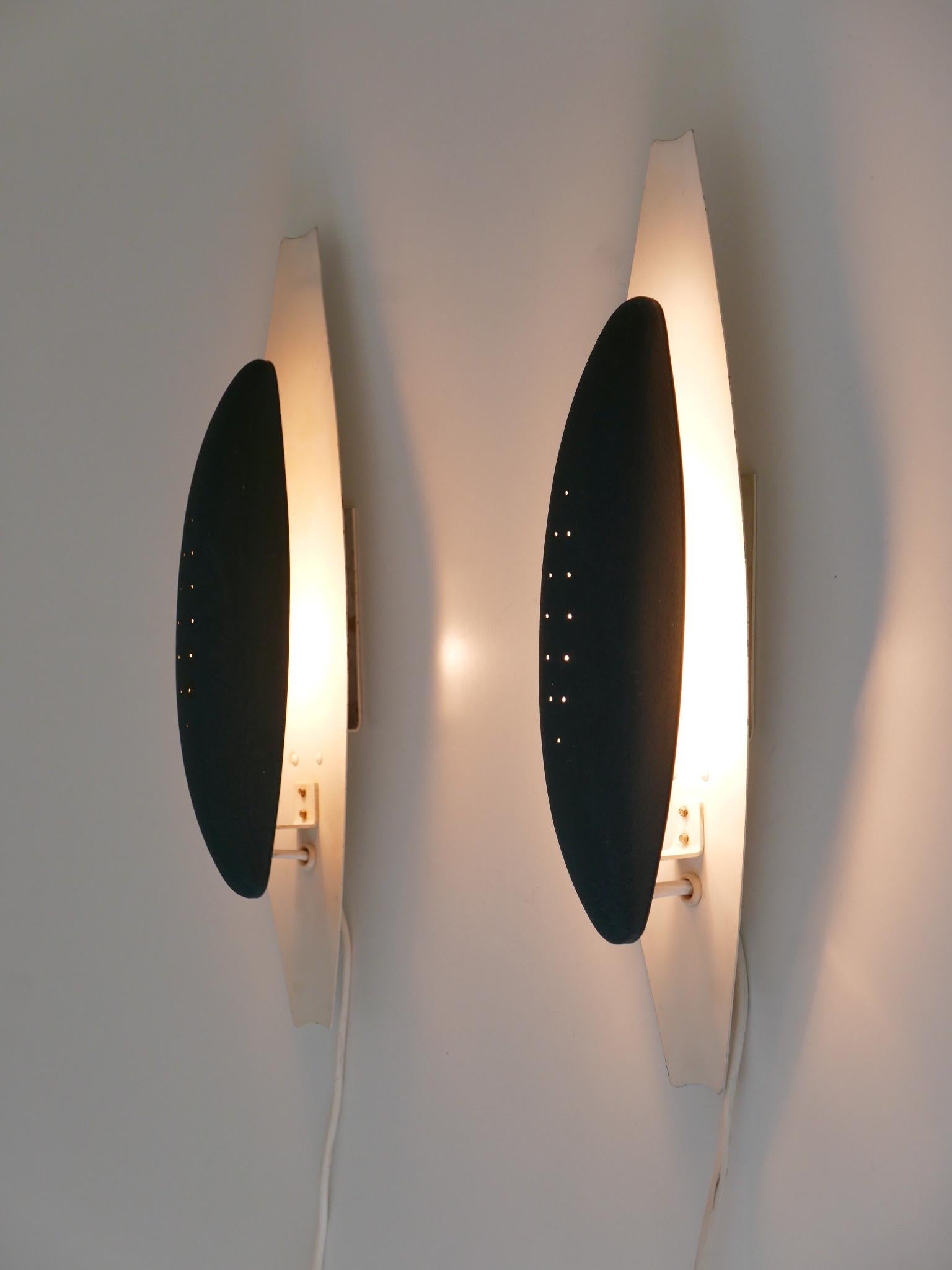 Set of two extremely rare, elegant and highly decorative Mid-Century Modern Scandinavian wall lights / sconces with perforated lamp shades. Designed and manufactured probably in Sweden, 1950s.

Executed in perforated and enameled aluminum and metal,