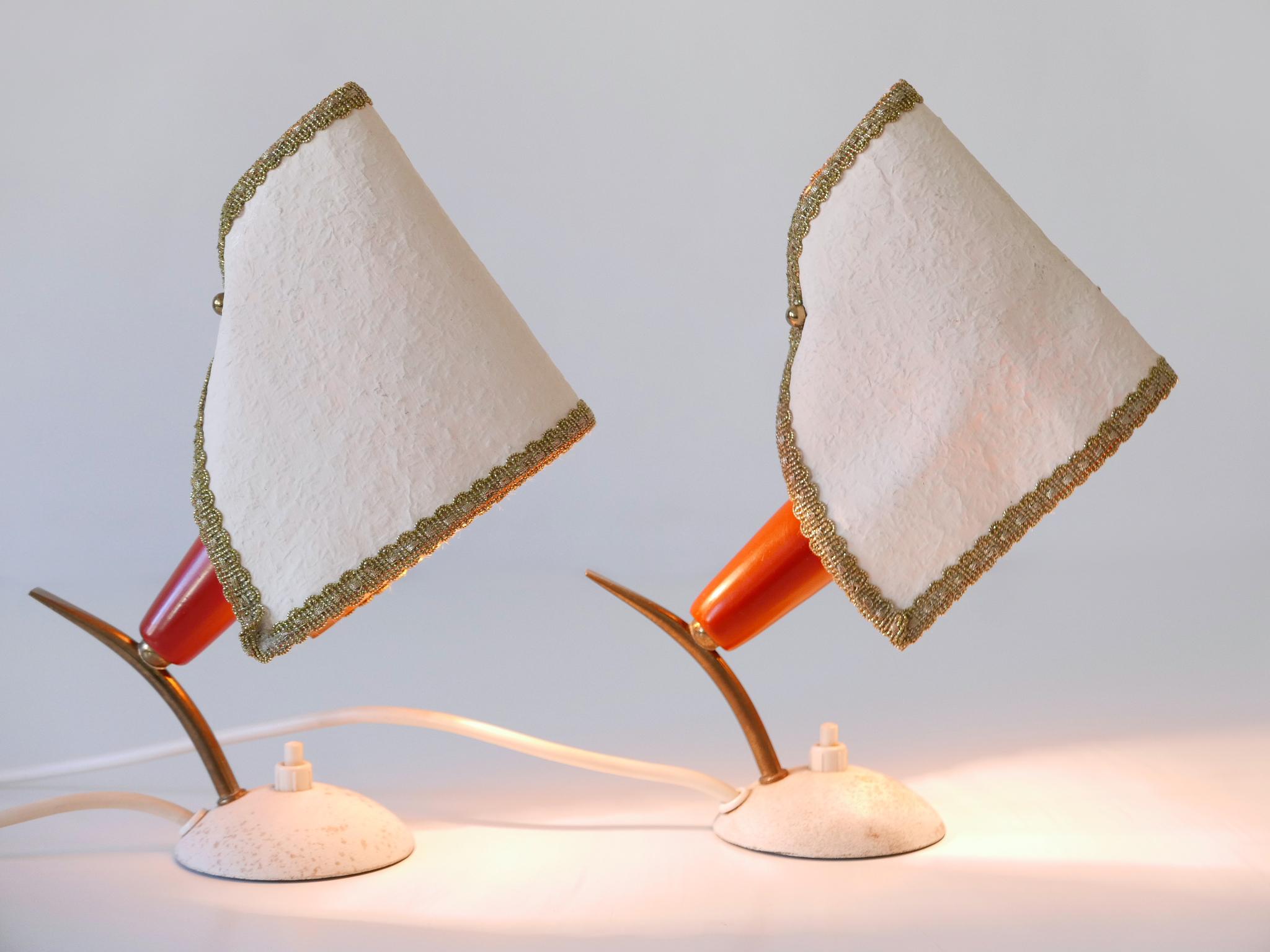 Set of two rare and lovely Mid-Century Modern bedside table lamps with parchment paper shades. Designed and manufactured in Germany, 1950s.

Executed in brass, metal and parchment paper, each lamp comes with 1 x E14 / E12 Edison screw fit bulb