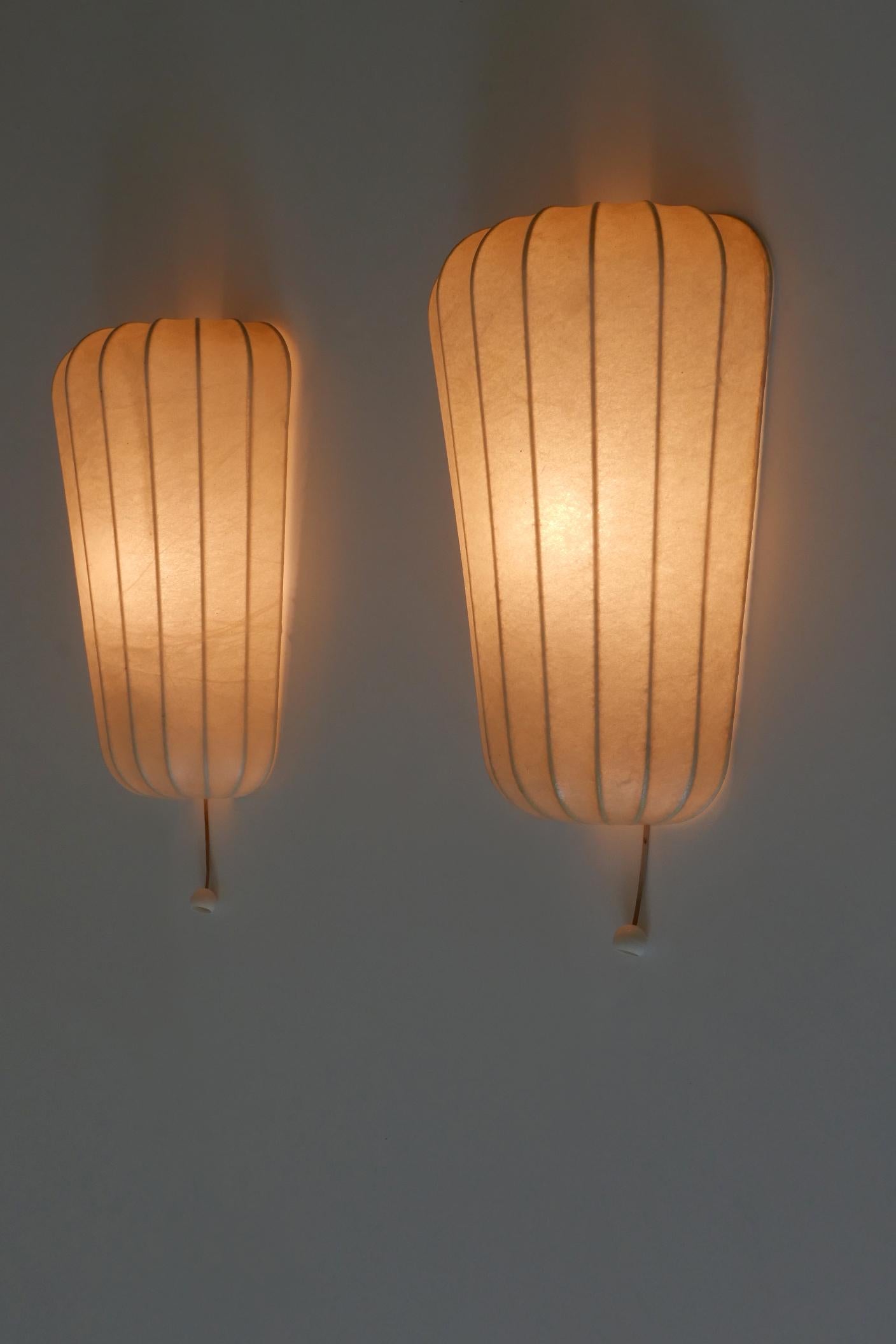 Set of two exceptional, elegant and highly decorative Mid-Century Modern cocoon sconces or wall fixtures. Designed probably by Friedel Wauer für Goldkant Leuchten, Germany, 1960s. 

Executed in resin and metal, each fixture is executed with 1 x E14
