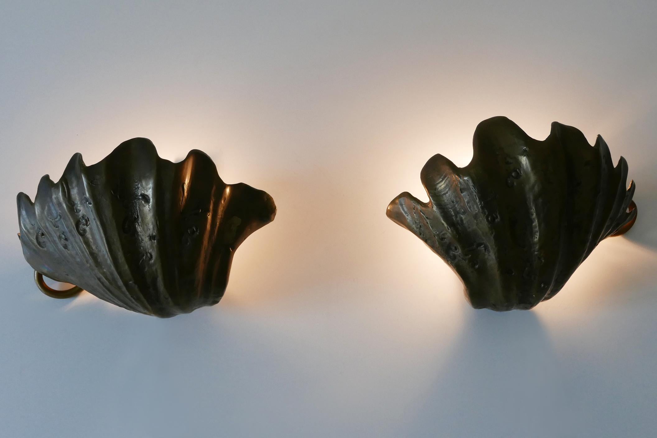 Set of two exceptional, elegant and highly decorative Mid-Century Modern cast bronze sconces or wall fixtures in shape of a sea shell. Designed & manufactured probably in Germany, 1960s. 

Executed in cast bronze and brass, each fixture is executed