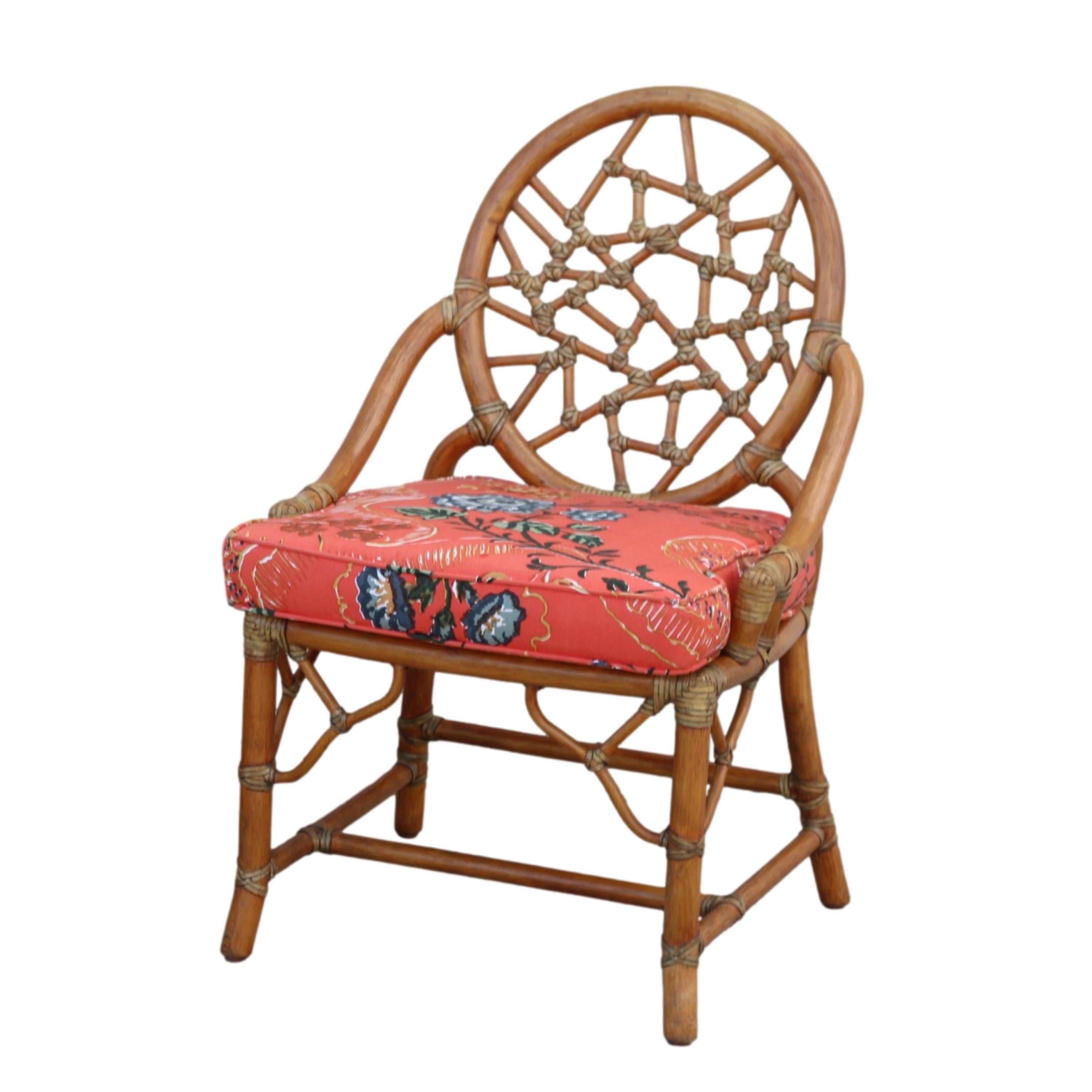 A set of two rattan cracked ice style chairs, in the manner of McGuire, with an ottoman. The chair design features a rattan oval back that frames smaller rattan pieces bound by leather, creating the impression of cracked ice or shattered glass. The