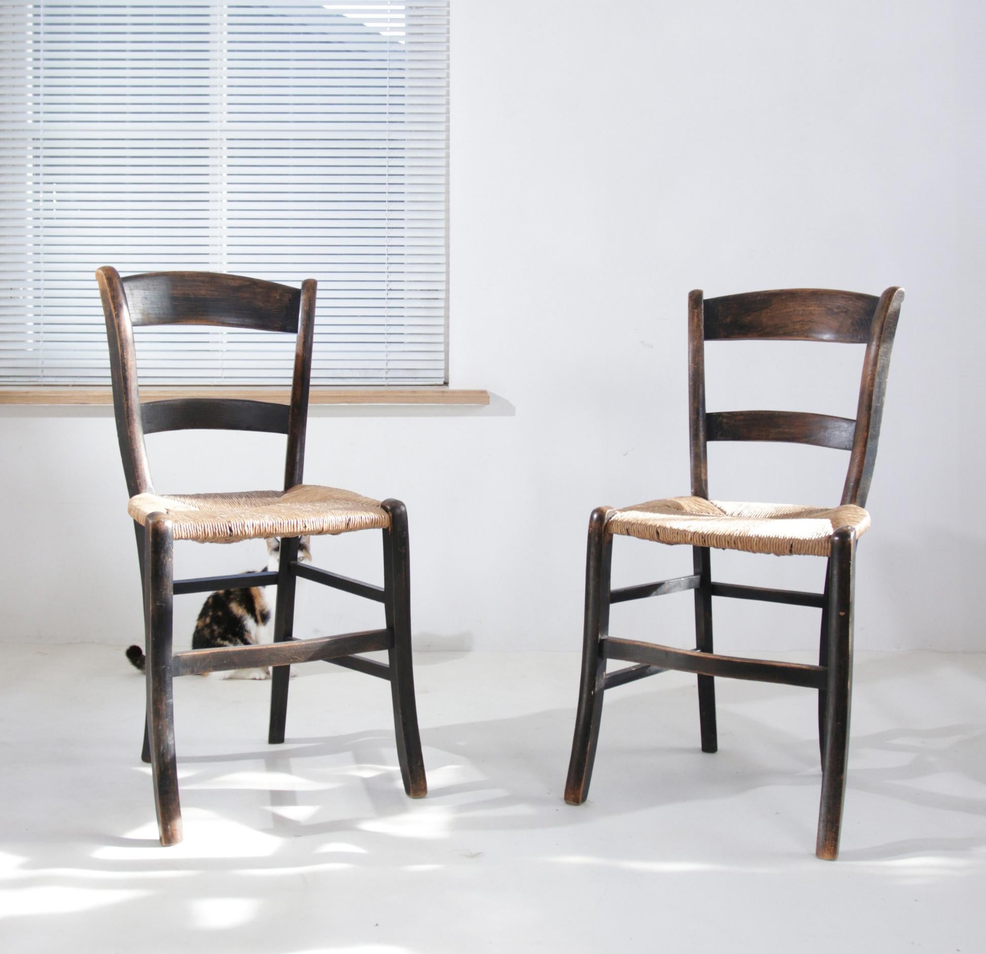 Diese eleganten Holzstühle, die vermutlich aus der Zeit Anfang bis Mitte des 20. Jahrhunderts stammen, sind ein Symbol für die Handwerkskunst dieser Zeit. Der dunkel gefärbte und in seiner Schlichtheit anmutige Holzrahmen verbindet Funktionalität