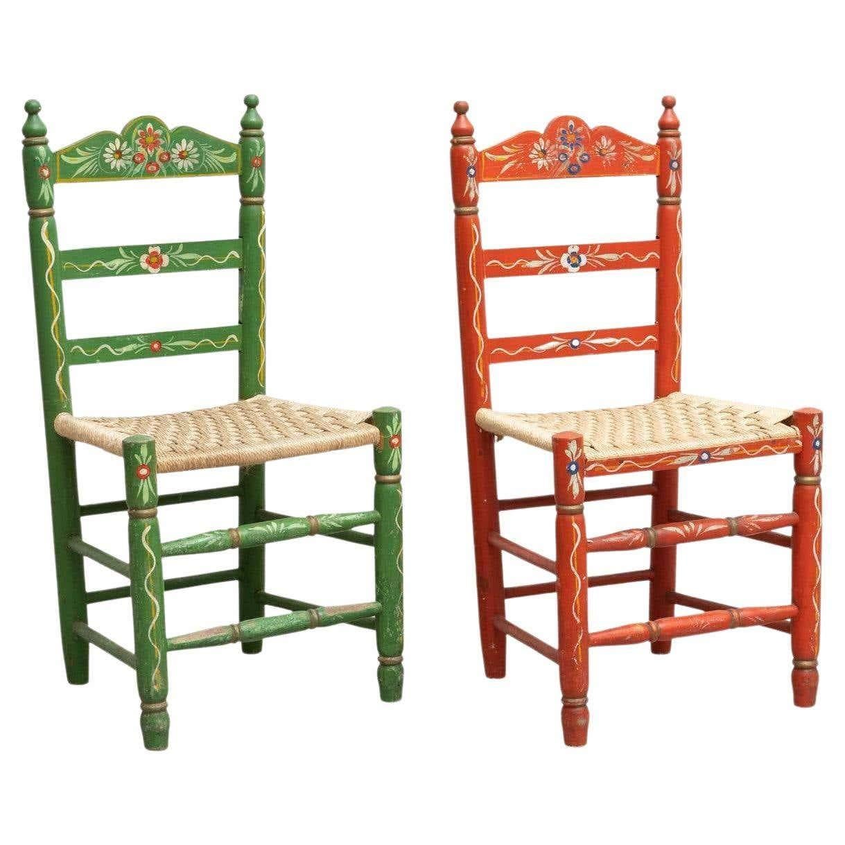 Ensemble de deux chaises en bois rustiques peintes à la main.

Par un artisan inconnu en Espagne, vers 1940.

En bon état d'origine, avec une usure mineure conforme à l'âge et à l'usage, préservant une belle patine.

Matériaux :
Le bois.

