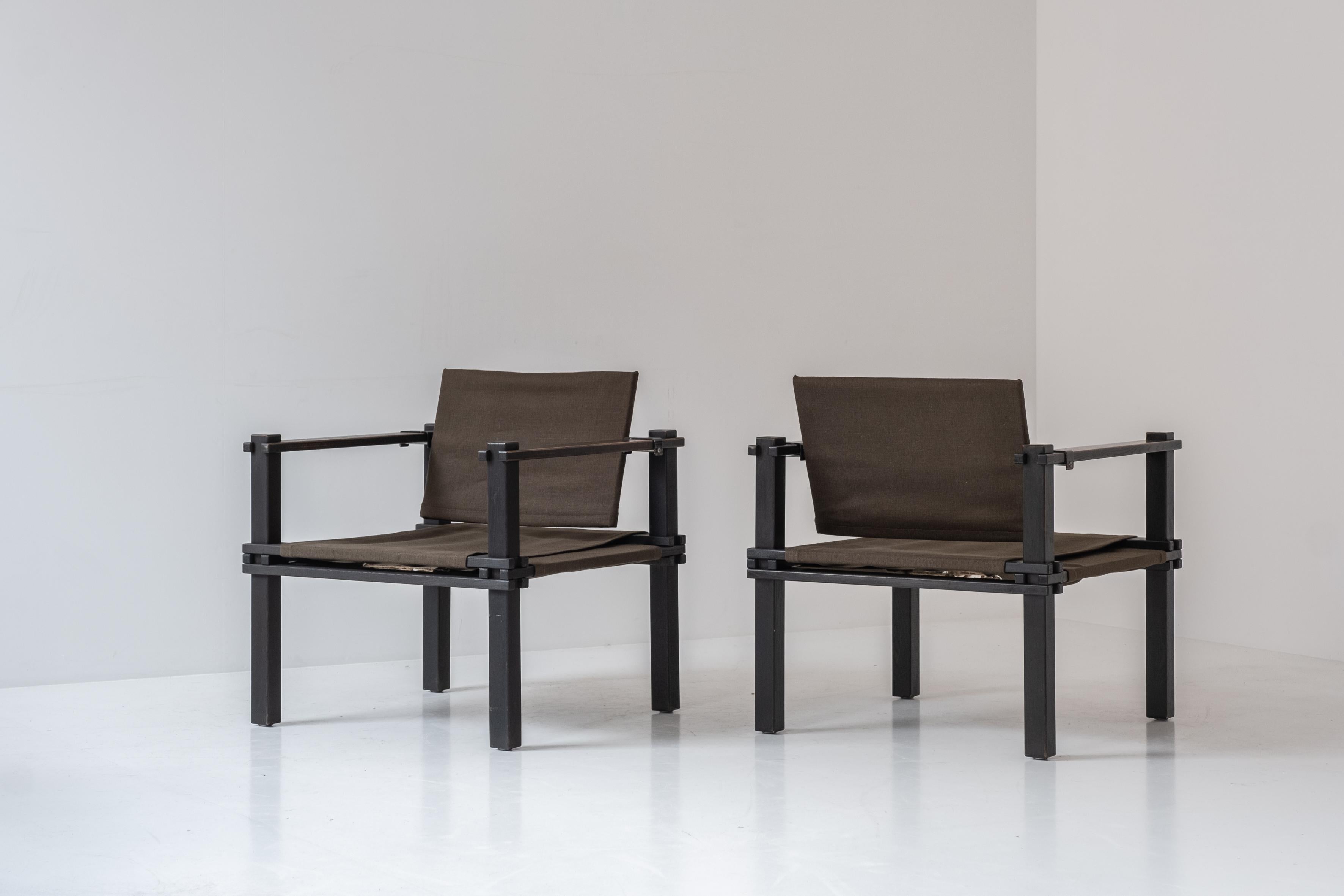 Set of two Safari easy chairs by Gerd Lange for Bofinger, Germany 1960s. These chairs features stained oak frames and fabric seats and backs. These architectural chairs are set up with only wooden elements, no screws where used to assemble. The