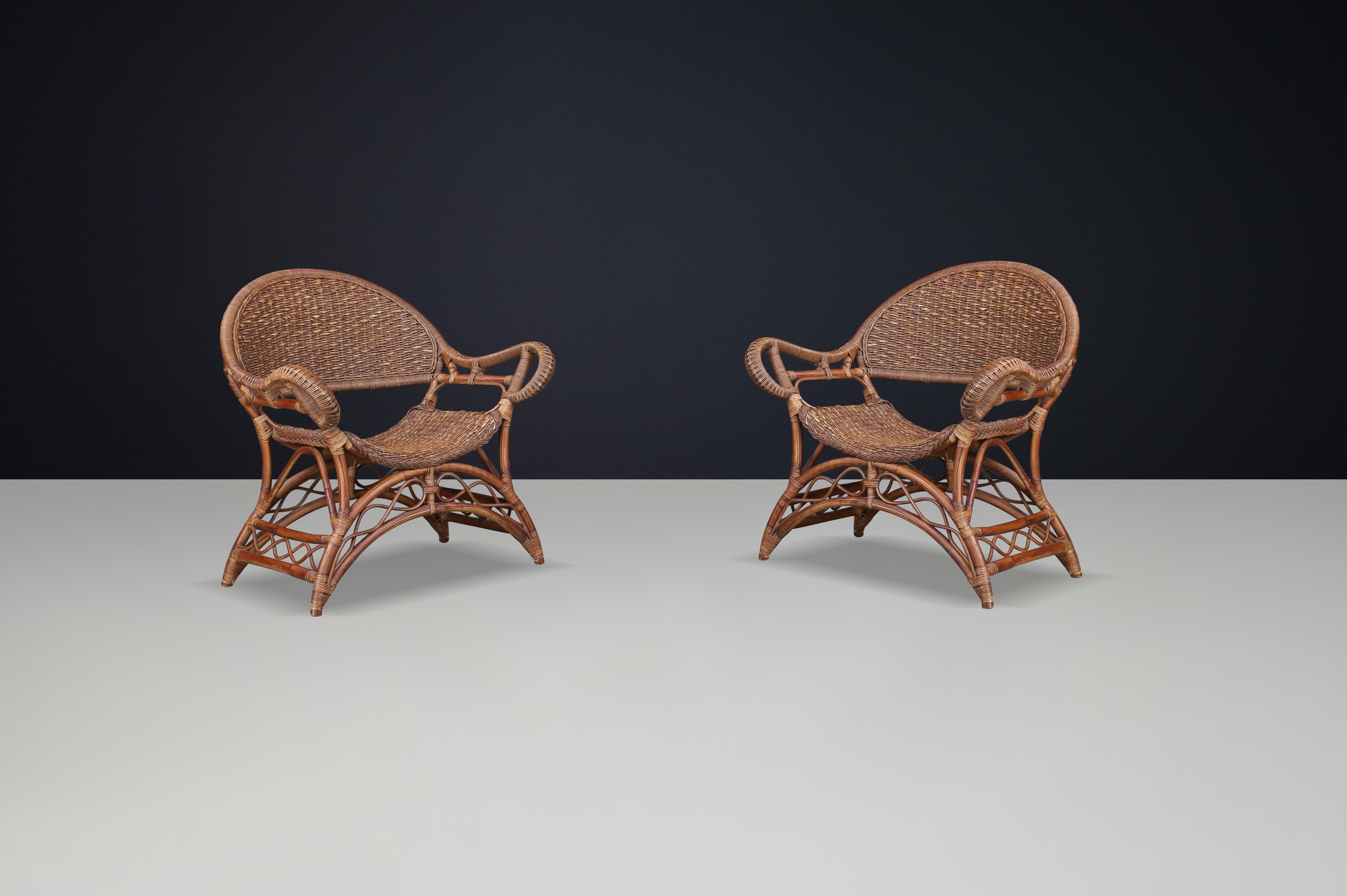 Set of Two Sculptural Rattan and Bamboo Lounge Chairs, Spain, 1960s

Description:
A beautiful and rare set of two sculptural armchairs crafted in Spain during the 1960s. These chairs are an exquisite example of Mediterranean craftsmanship,