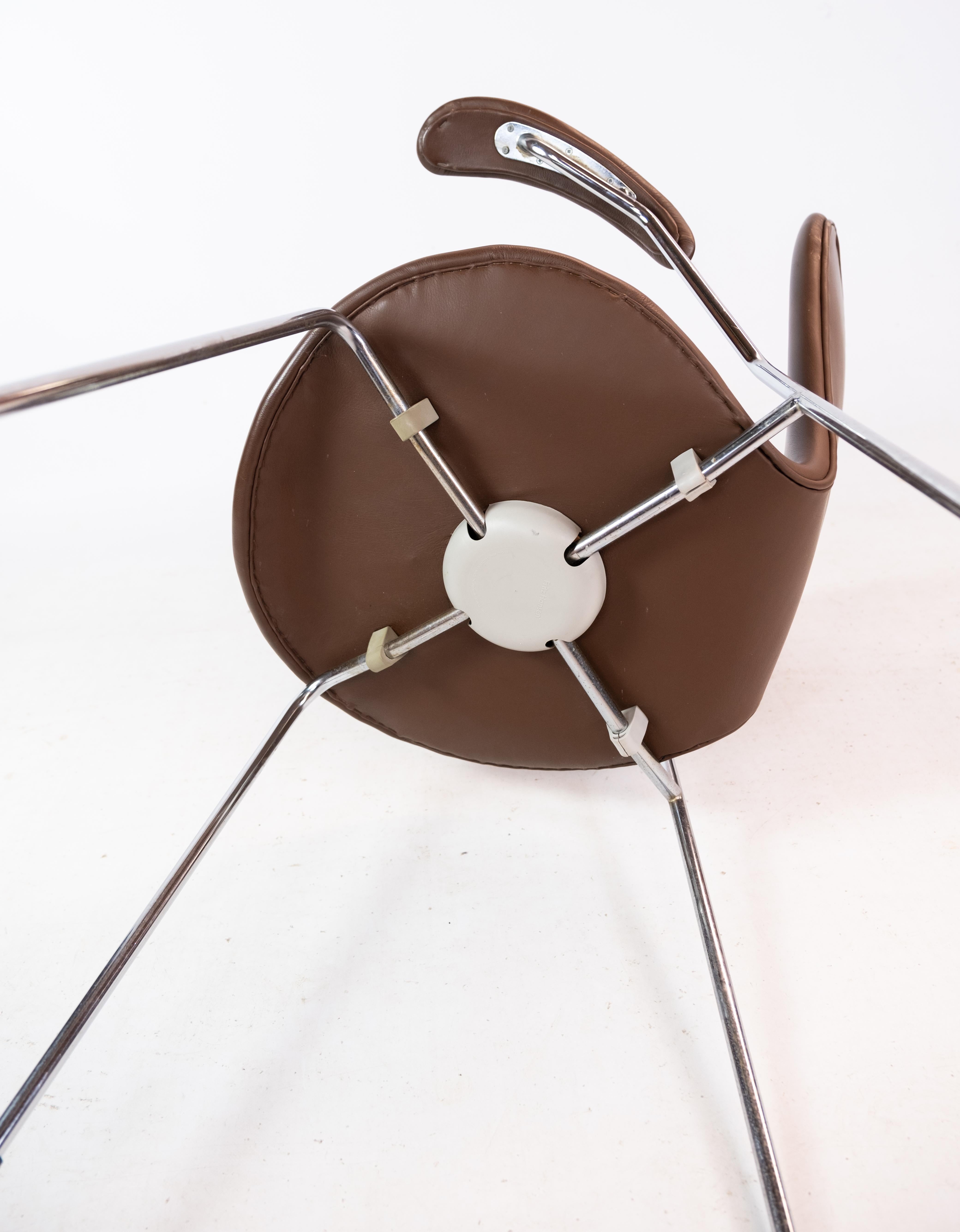 Der 7 mit Armlehnen und Vollpolsterung aus Leder ist ein klassischer Entwurf von Arne Jacobsen. Dieser Stuhl ist unglaublich vielseitig und passt perfekt an jeden Esstisch, in die Küche oder ins Büro. Er ist ein Favorit in modernen und aufregenden