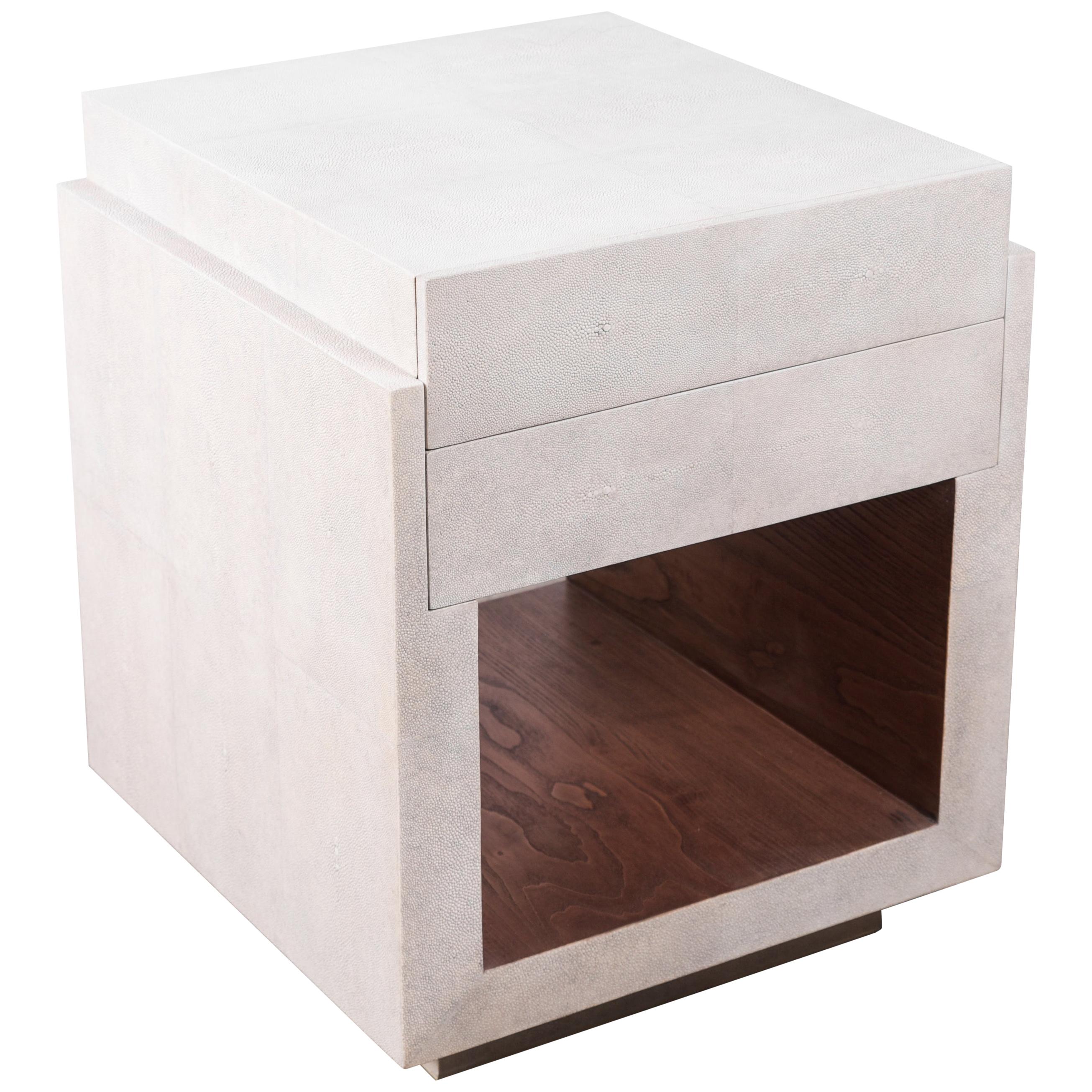 The tomboy bedside by R&Y Augousti is an elegant piece with its subtle geometry. This bedside table is completely inlaid in a mixture of cream shagreen and gemelina wood veneer in the shelf opening. This bedside table includes two drawers and a