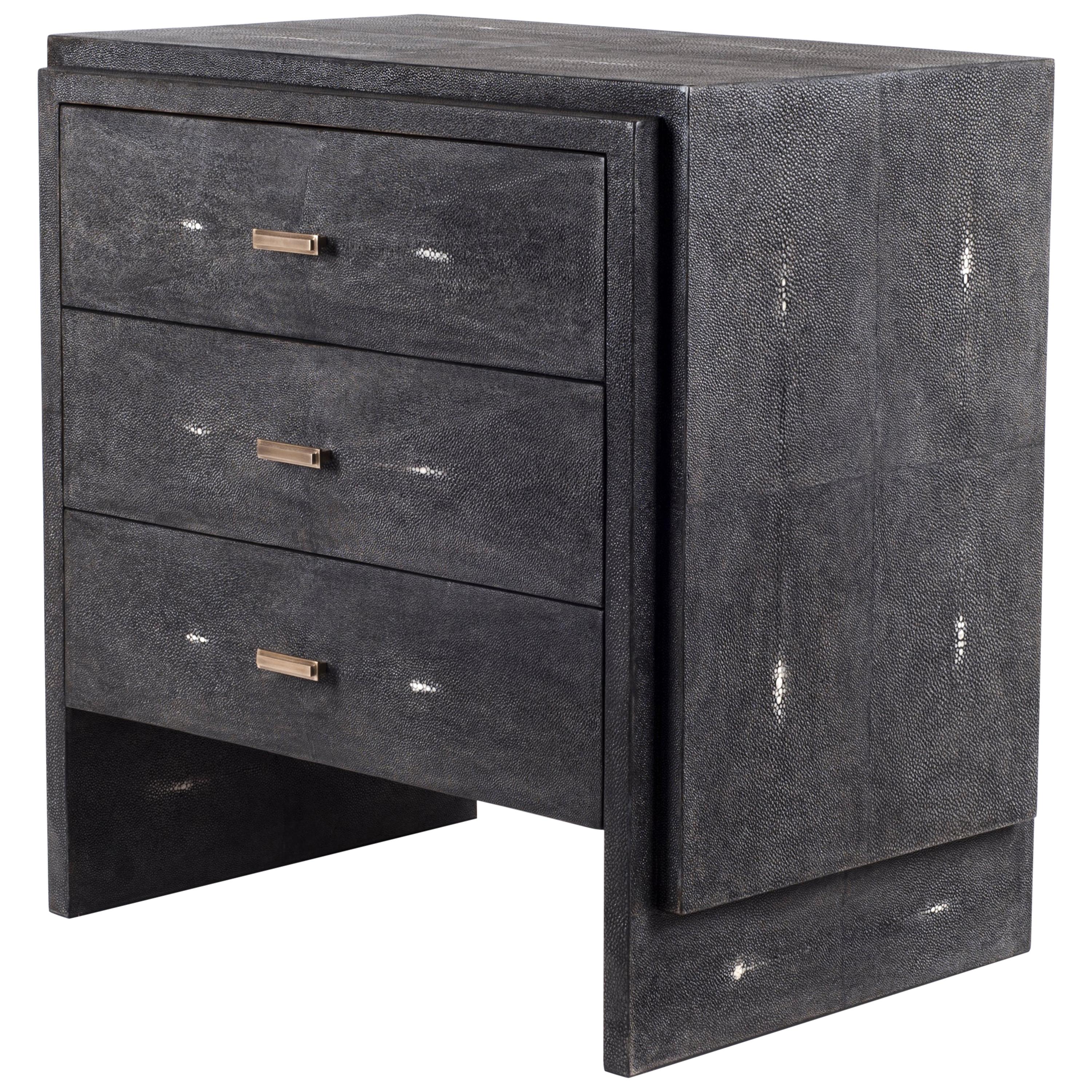 The iconic bedside by R&Y Augousti is one of their first designs. A Classic and functional bedside table, with subtle geometry on the beveled drawers. This bedside table is completely inlaid in coal black shagreen with discreet bronze-patina brass