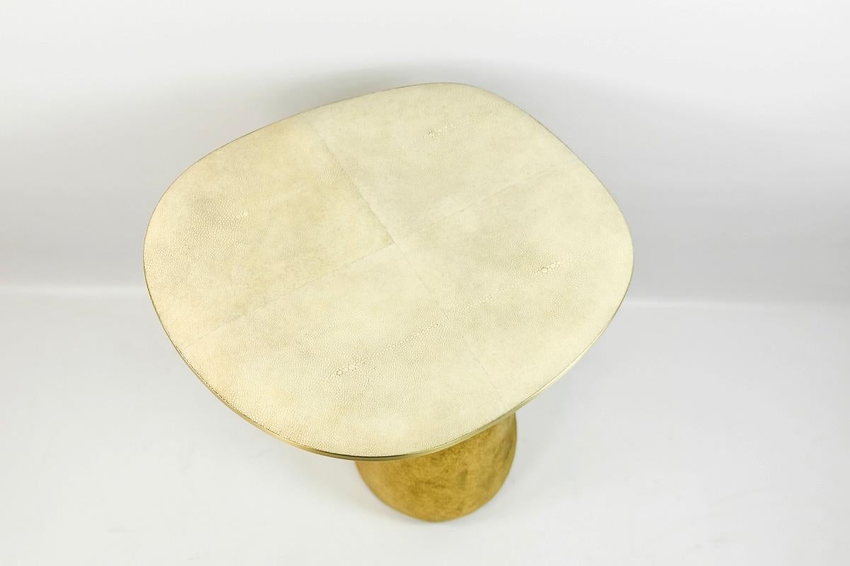 This set of 2 tables is made of a shagreen top with brass trims.
The base is made of wood with a gilded semi-raw glass fiber inlaying.
The semi raw finishing brings an interesting texture thanks to the nice organic shape of the tables.

The