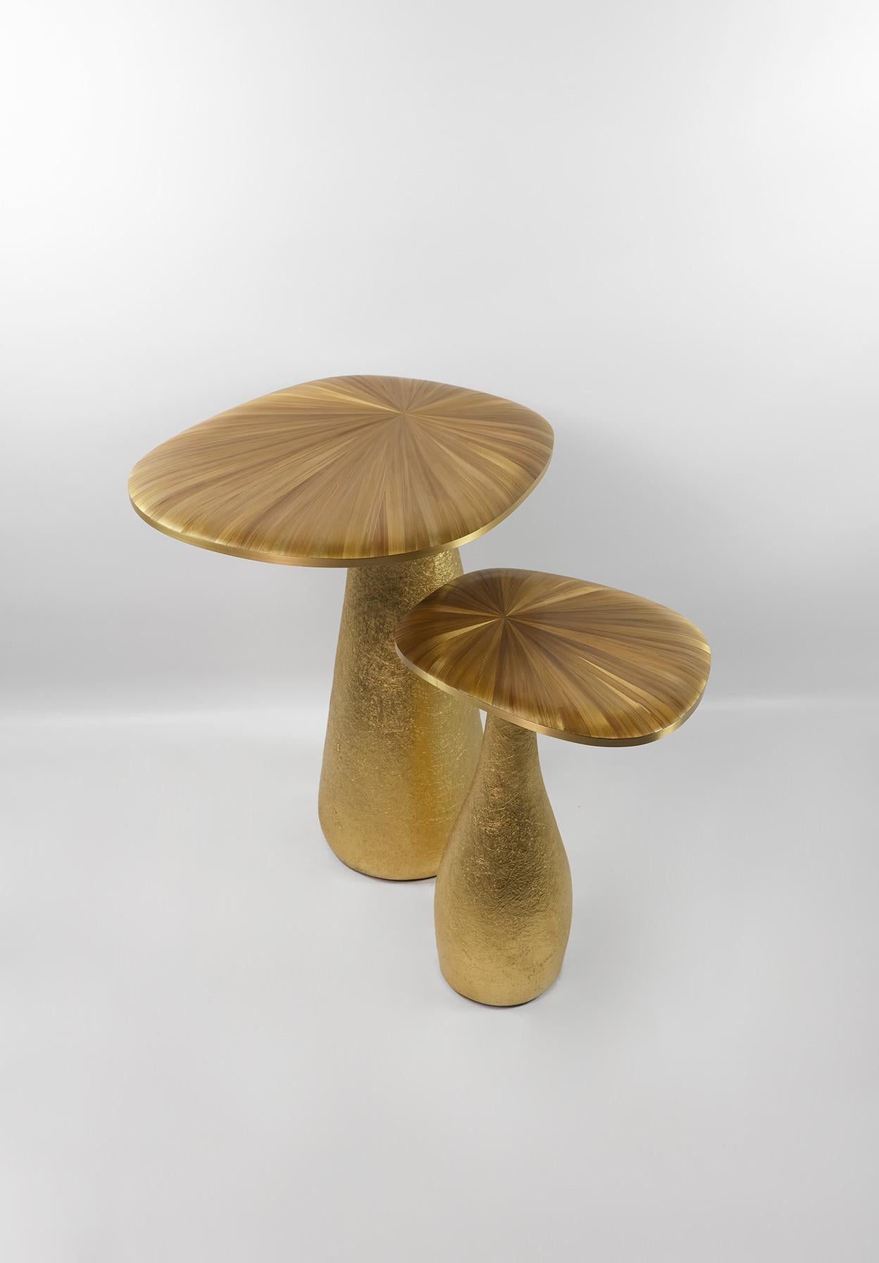 This set of 2 tables is made of straw marquetry top with brass trims.
The base is made of wood with a gilded semi-raw fiberglass inlaying.
The semi raw finishing brings an interesting texture thanks to the nice organic shape of the tables.
The straw