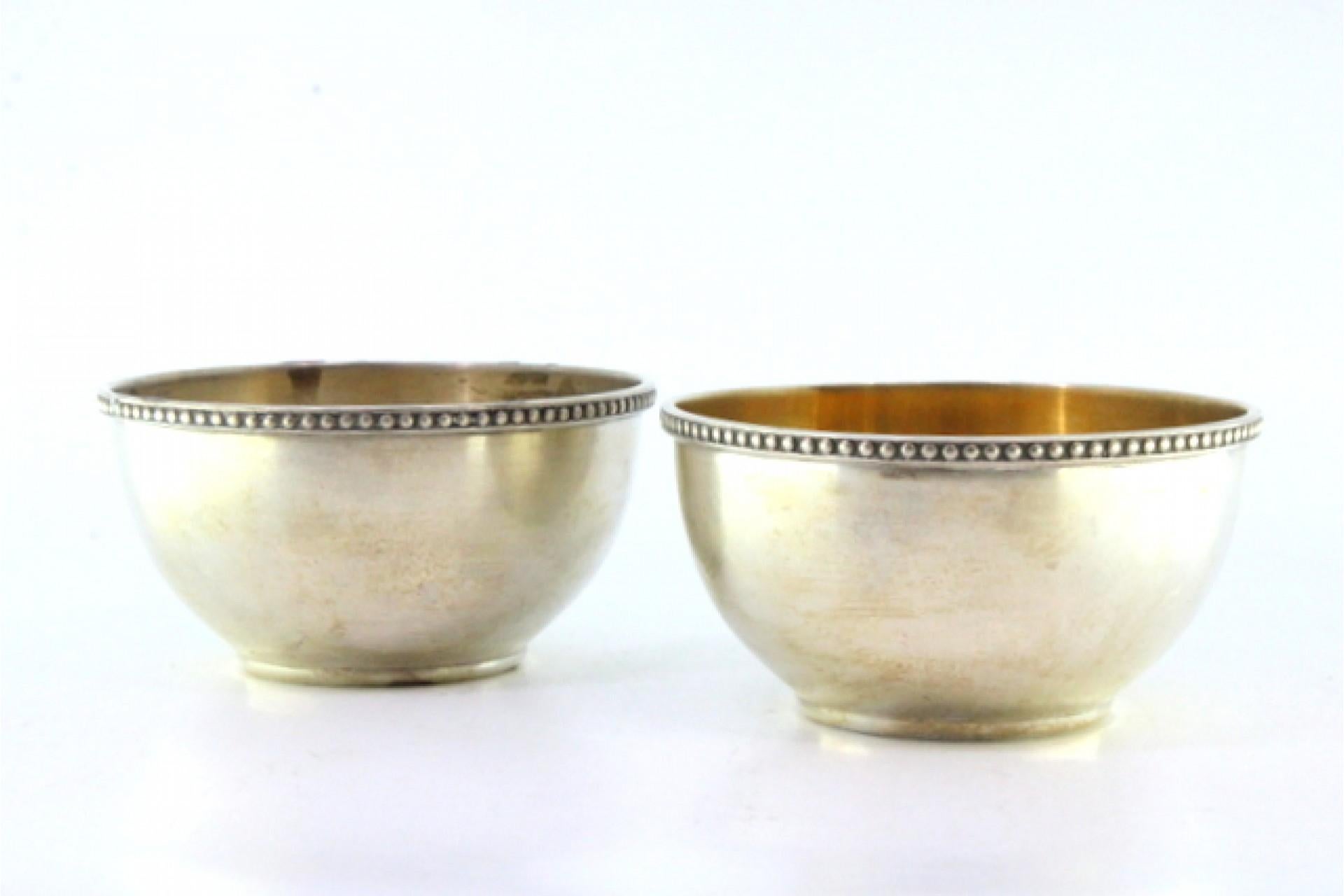 Description: Set of two silver washbasins with pearly edges and gold interiors. Metal: Silver. Origin: Portuguese. Mark: standing eagle. Weight: 204.22 grams (Set of two washbasins). Dimensions: 29.2cmx23.7cm. Content: 833/1000. Assay Mark: Yes,