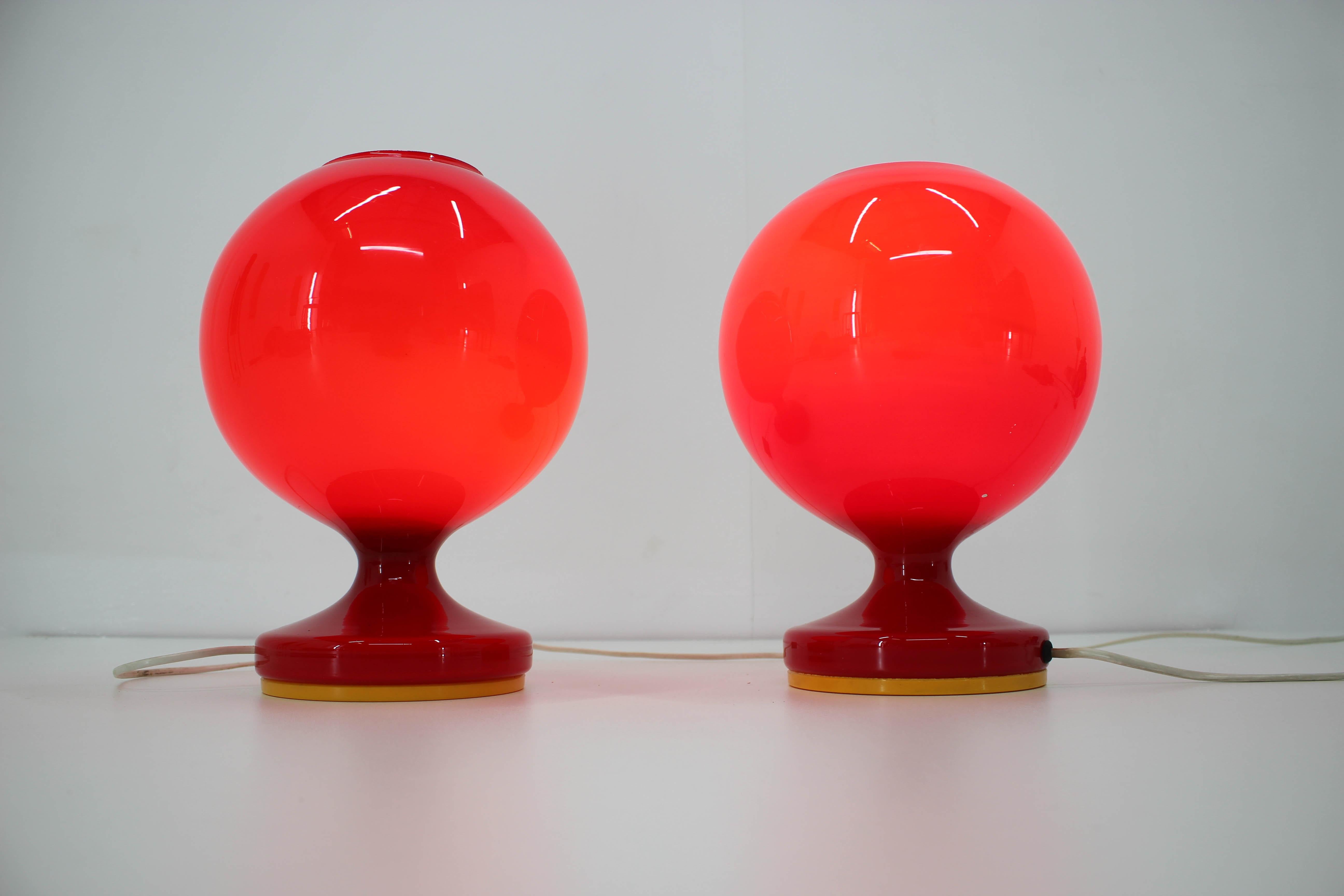 Set of two red glass table lamp designed by Stepan Tabery for Osvetlovaci sklo, Valasske Mezirici.
Good original condition, small losses on the edge of one shade seen on photo
60w, E27 or E26 bulb
Labeled.   
 