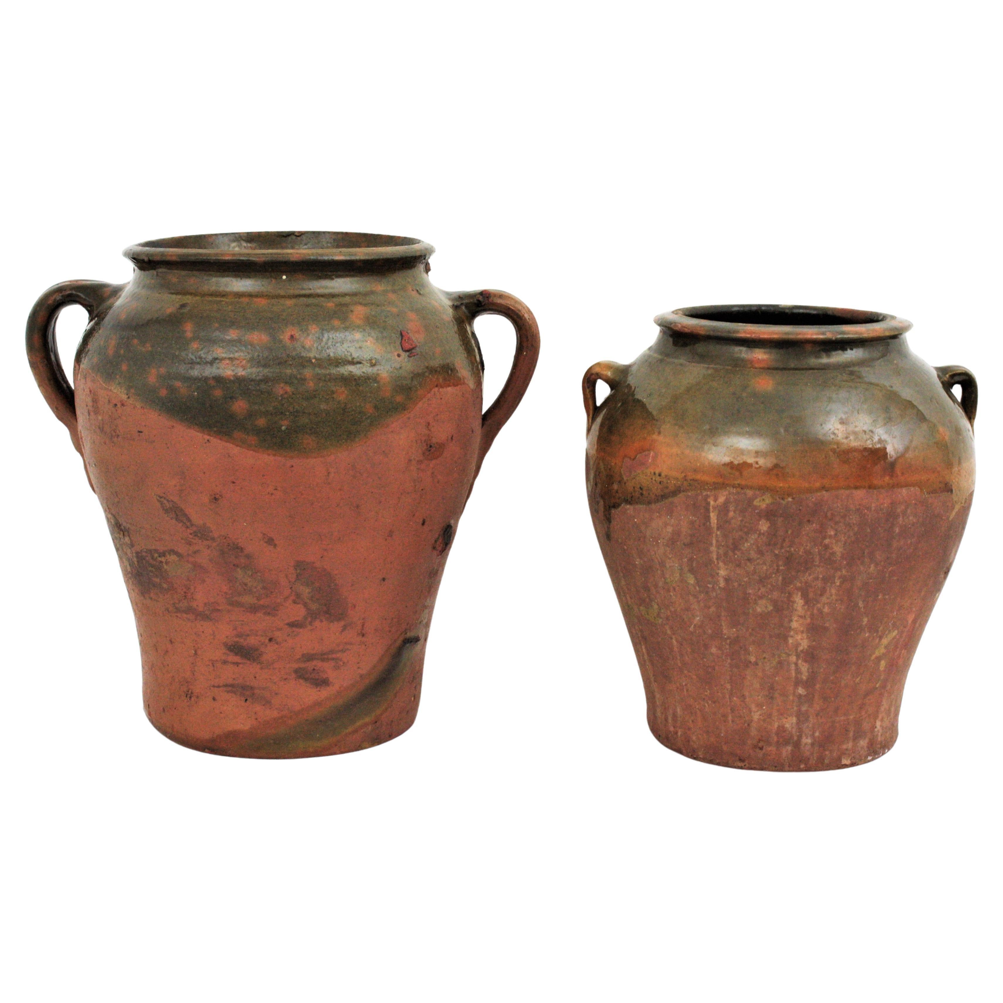 Handmade terracotta preserving pot or jar with handles from Segovia, Spain, 1930s
Two traditional Spanish ceramic 'orza'. Unglazed exterior with handles at both sides and green and brown color glaze on the top and at the interior to preserve olive