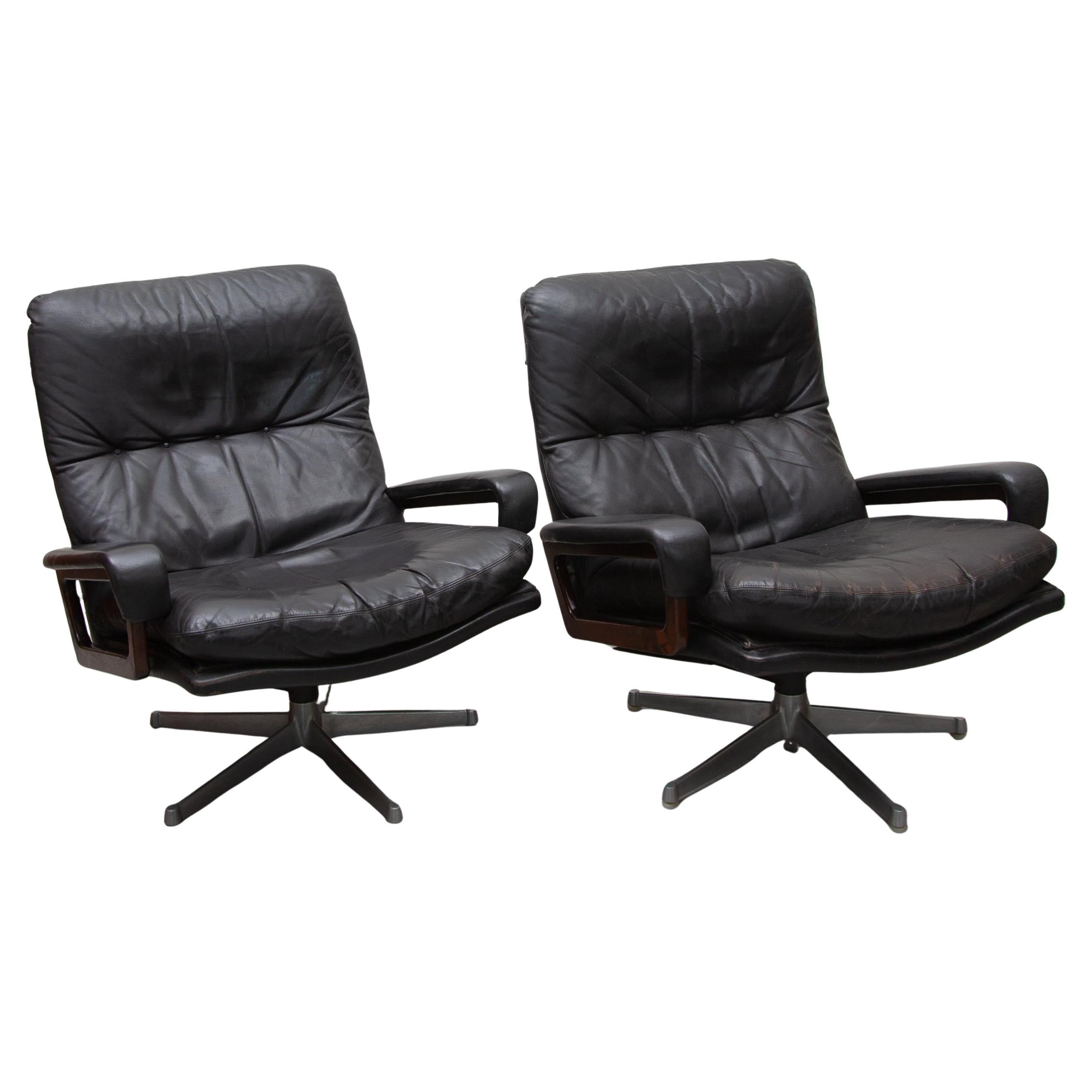 Ensemble de deux fauteuils de salon pivotants en cuir noir et accoudoirs en noyer conçu par Strässle, Suisse, années 60 conçu par André Vandenbeuck, designer belge travaillant pour la manufacture en Suisse, le siège pivote à 360 degrés vers la