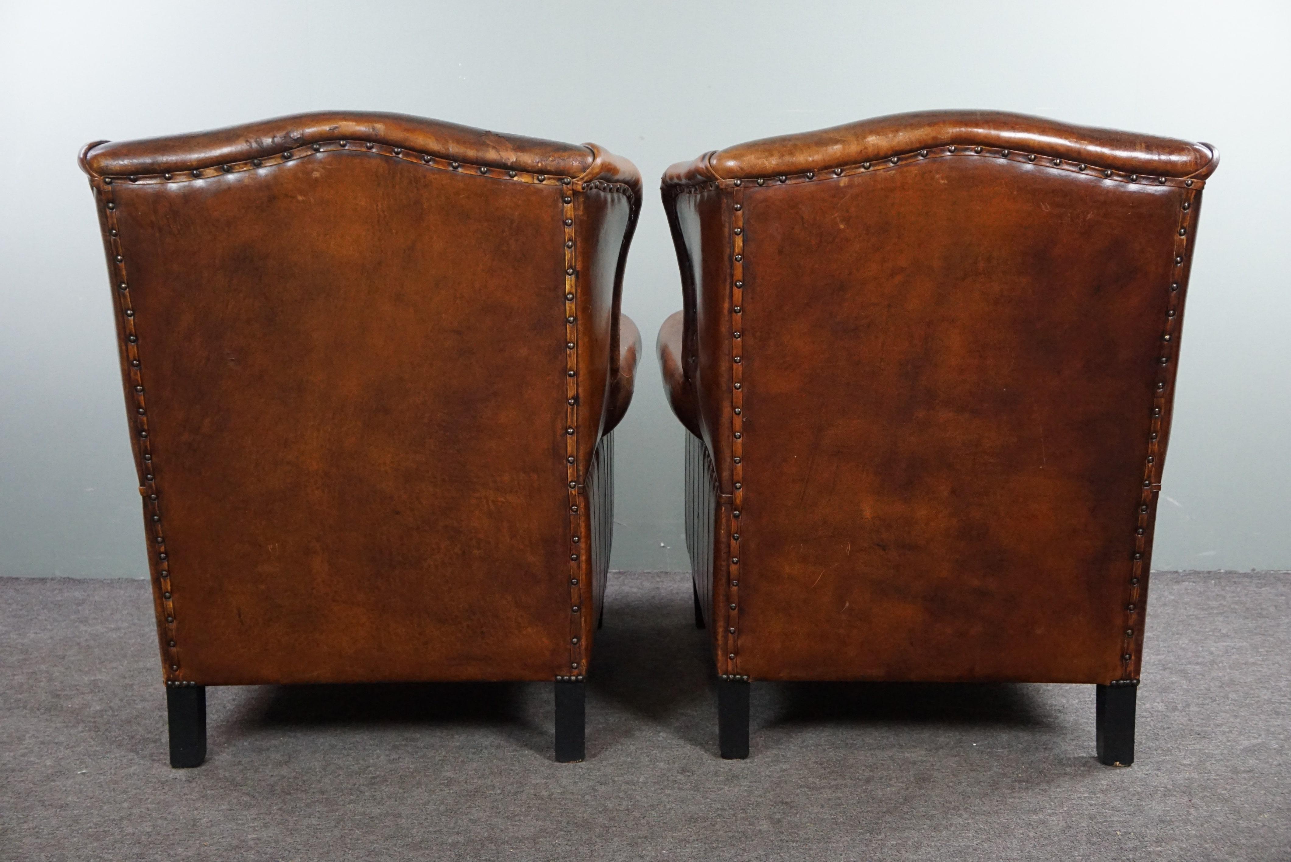 Hand-Crafted Set of two stylish sheep leather wing chairs with red corduroy seat cushions For Sale