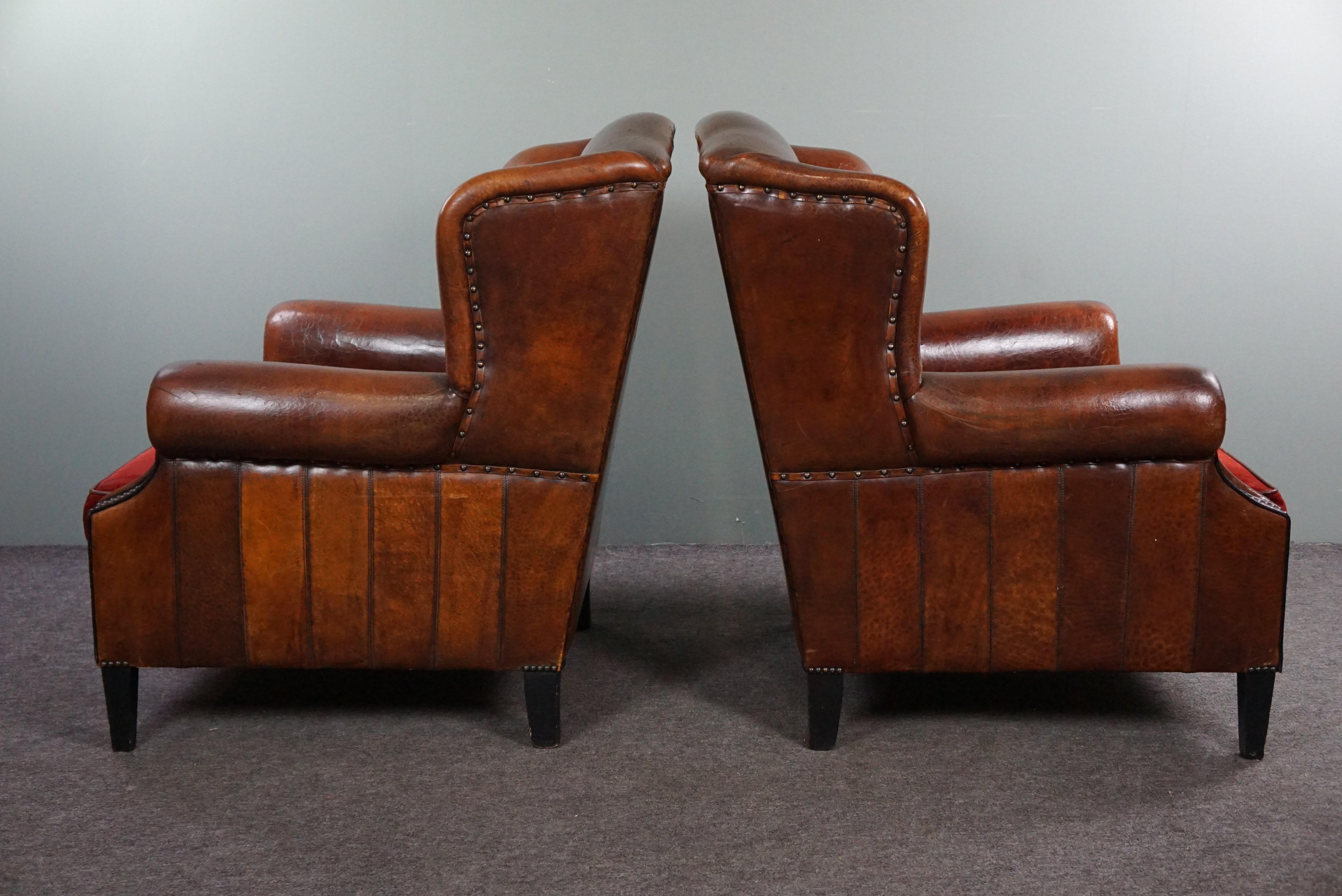 Set of two stylish sheep leather wing chairs with red corduroy seat cushions In Good Condition For Sale In Harderwijk, NL
