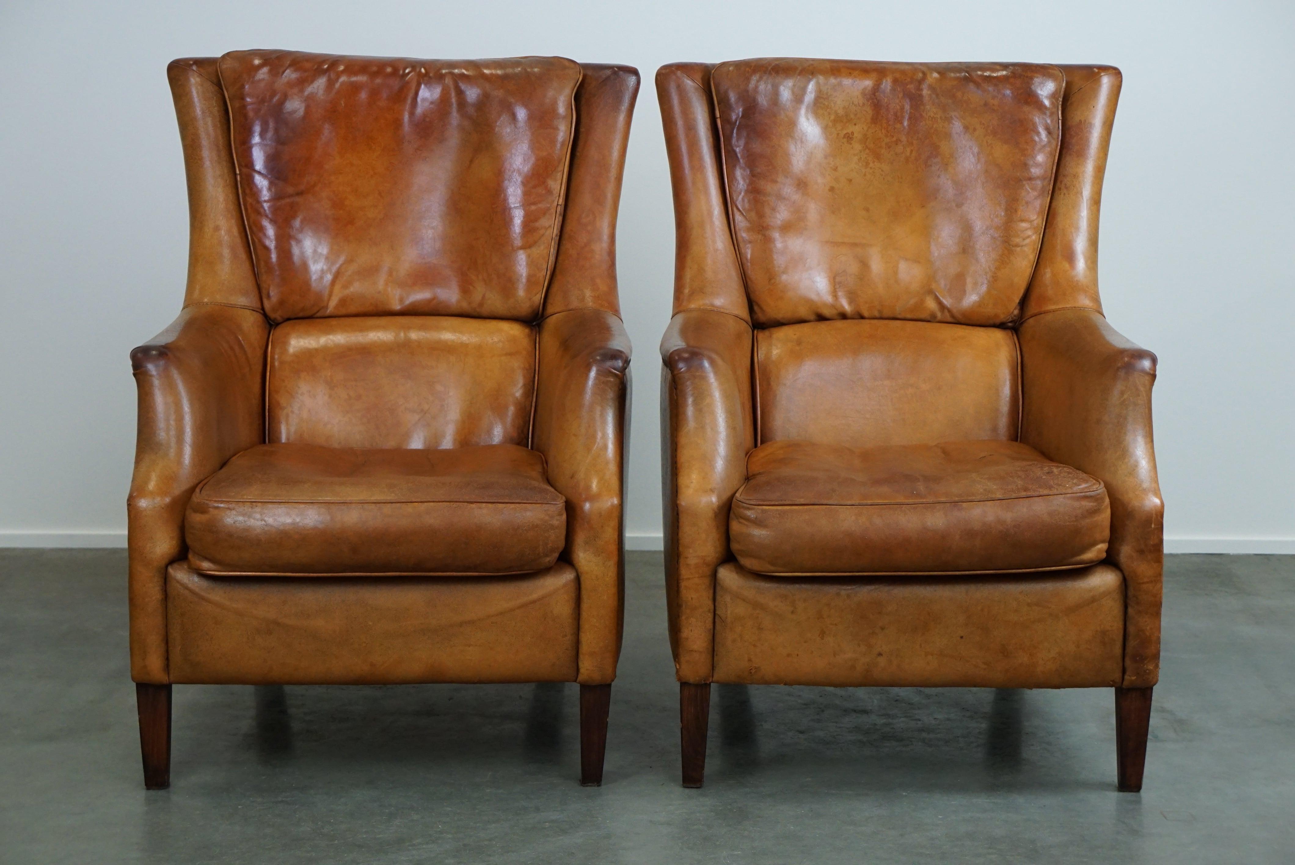 Offered: this set of two super rugged and very comfortable sheep leather armchairs with a beautiful patina.

Despite their rugged appearance, they will embrace you with their amazing comfort and quality. These are the perfect armchairs to sink into