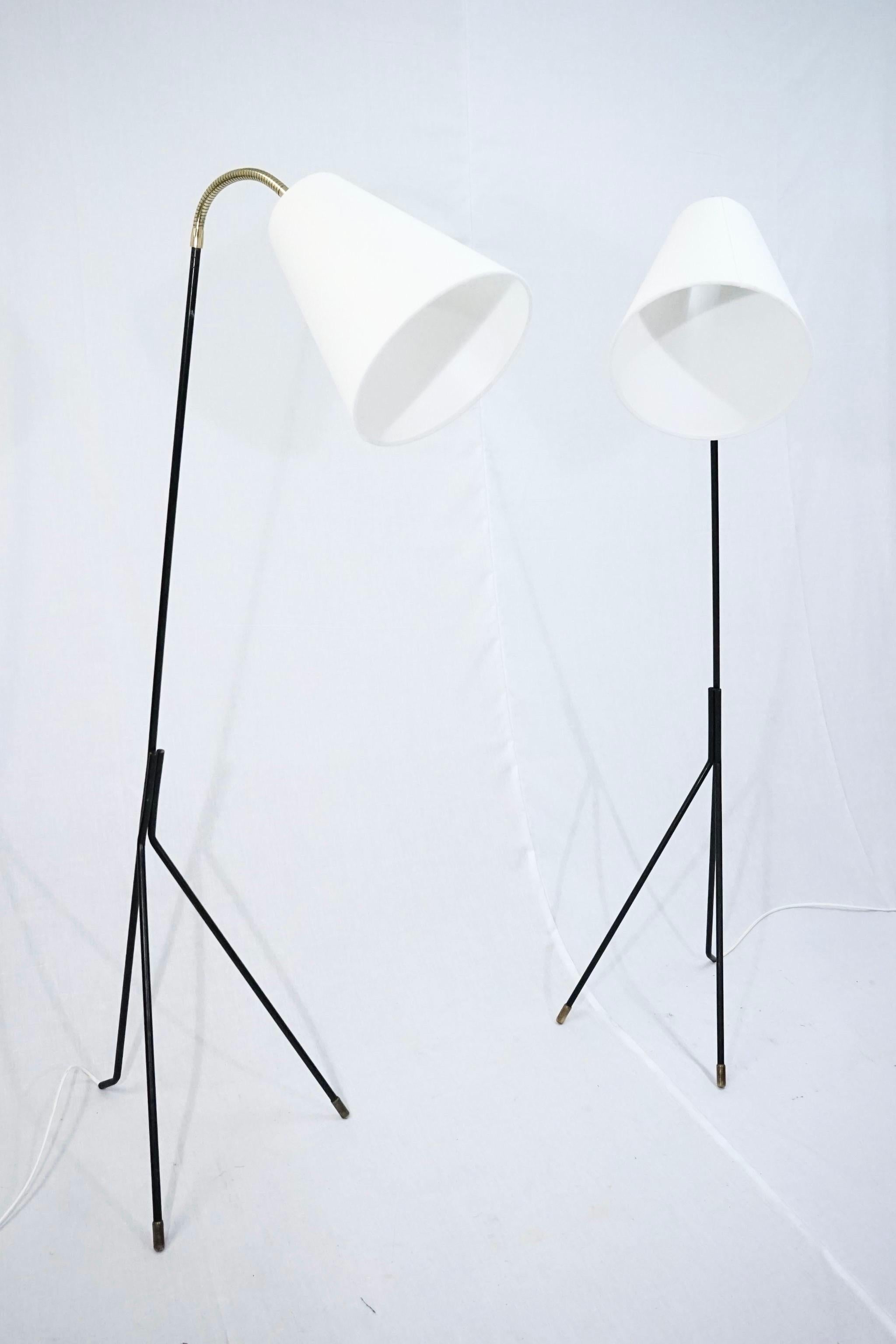 Rare set of two Svend Aage Holm Sørensen grasshopper floor lamps in original black lacquered metal with white fabric lamp shades. 
The lamps heads can be adjusted in any way because of the brass flex arms on both lamps.
The lamps have been newly