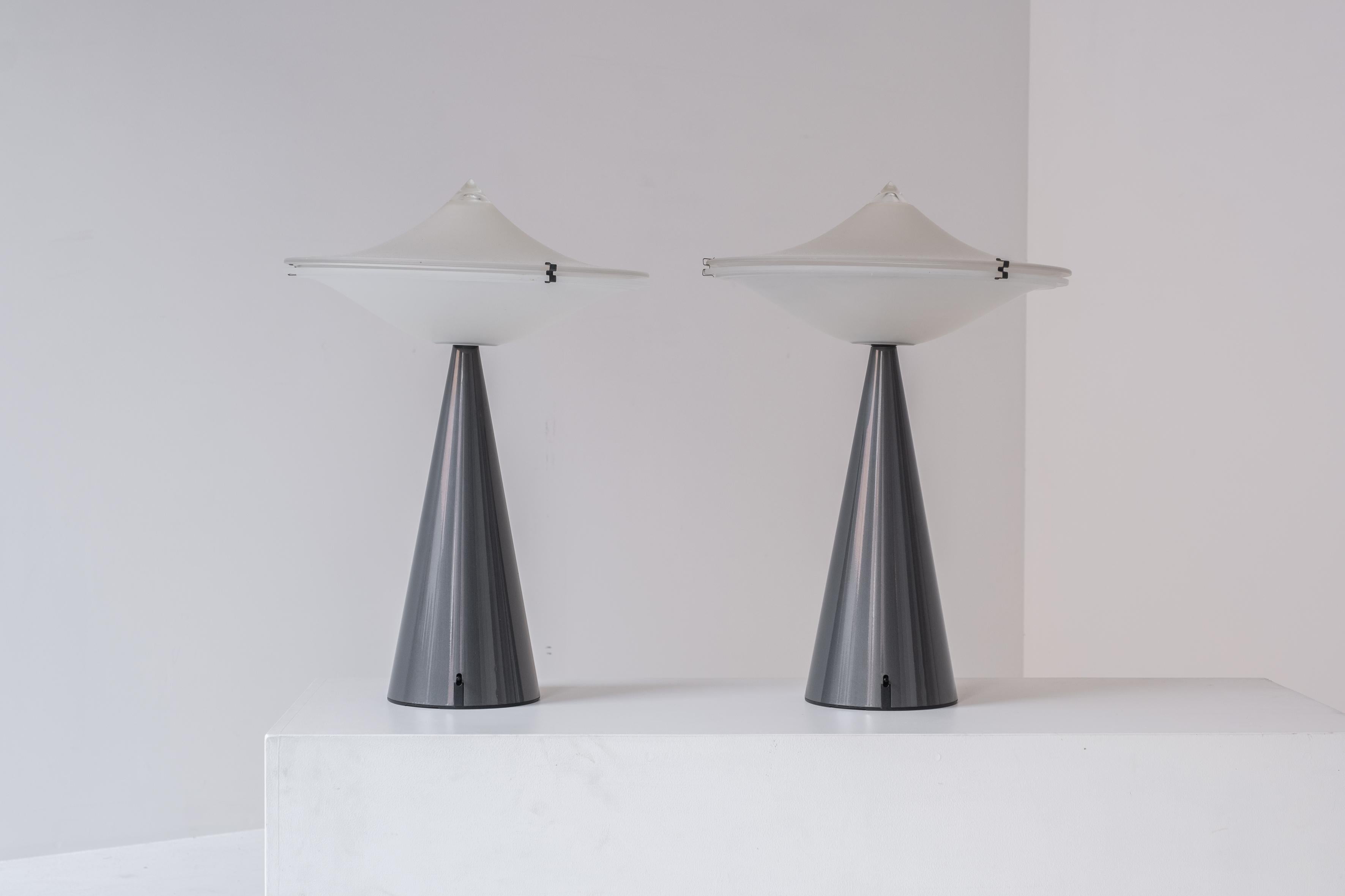 Set of two table lamps by Luciano Cesaro for Tre Ci Luce, Italy 1980s. The lamps features solid heavy metal bases in grey lacquer and two thick opaline milk glass shades. The base is provided with a switch that controls the halogen lamp inside. Very