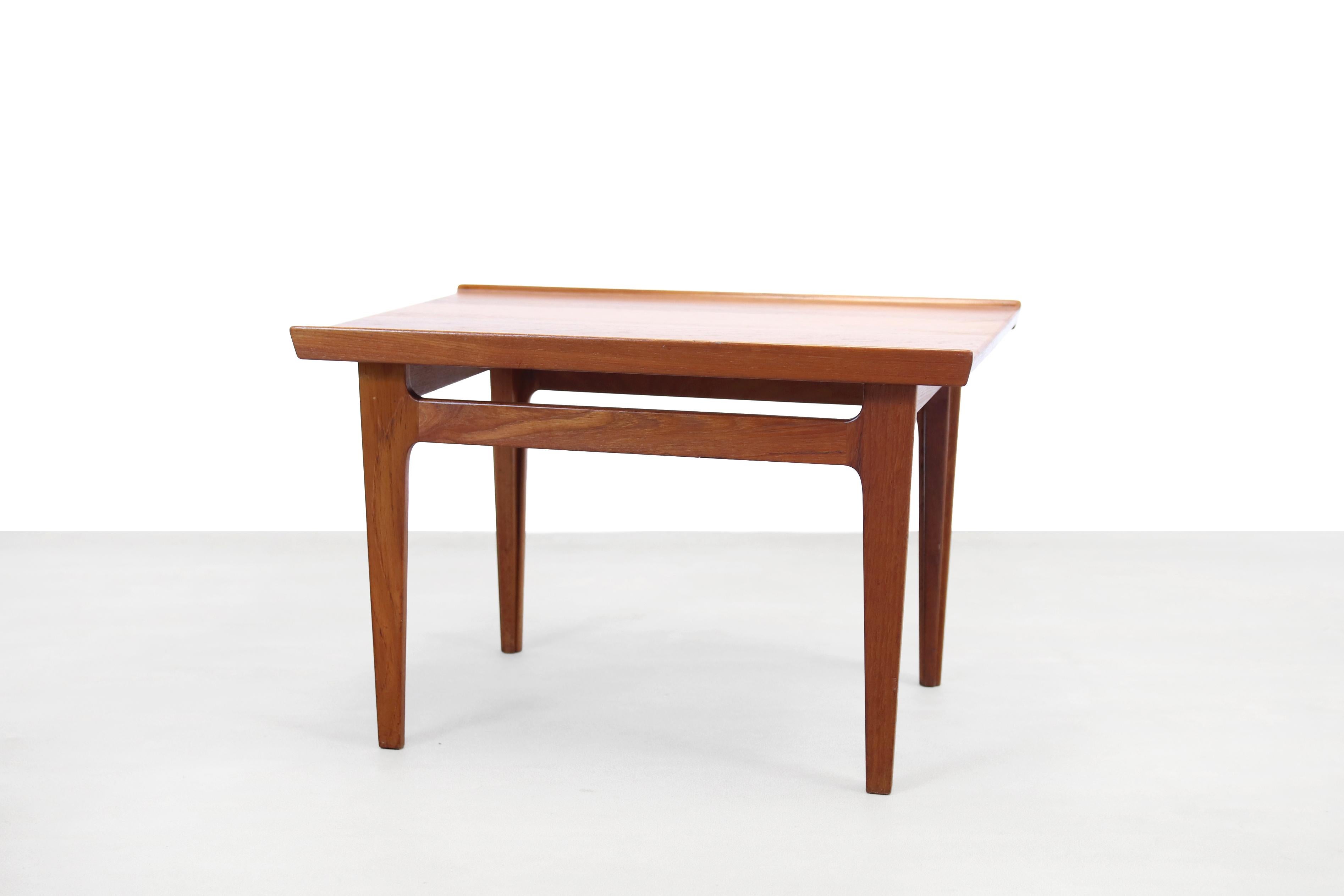Two special side tables made of solid teak. Designed by the great and well-known Danish designer Finn Juhl and produced by France and Son, Denmark in the 60s. The tables have a raised edge on two sides and the design of the legs has also been