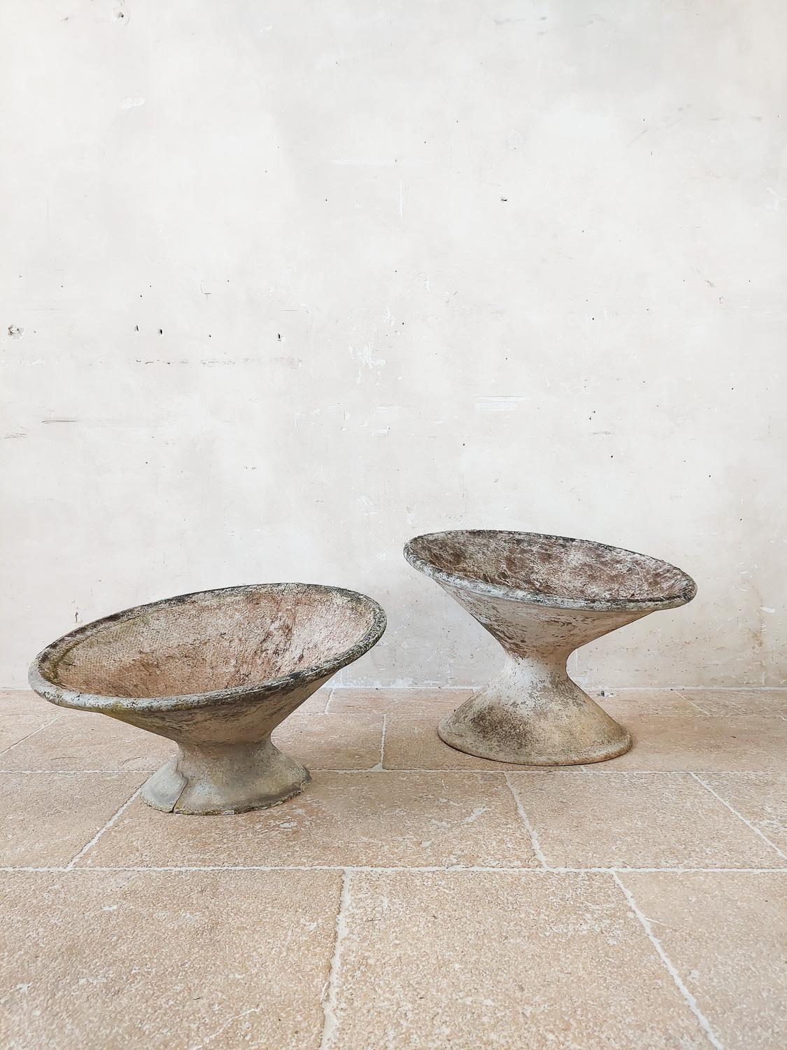 Set of two tilted concrete planters by the Swiss architect Willy Guhl. Beautiful patina and color. Great vintage planters or stand alone sculptures for indoor or outdoor use.

Some small damaging to one foot due to age, see photos

Measures:
