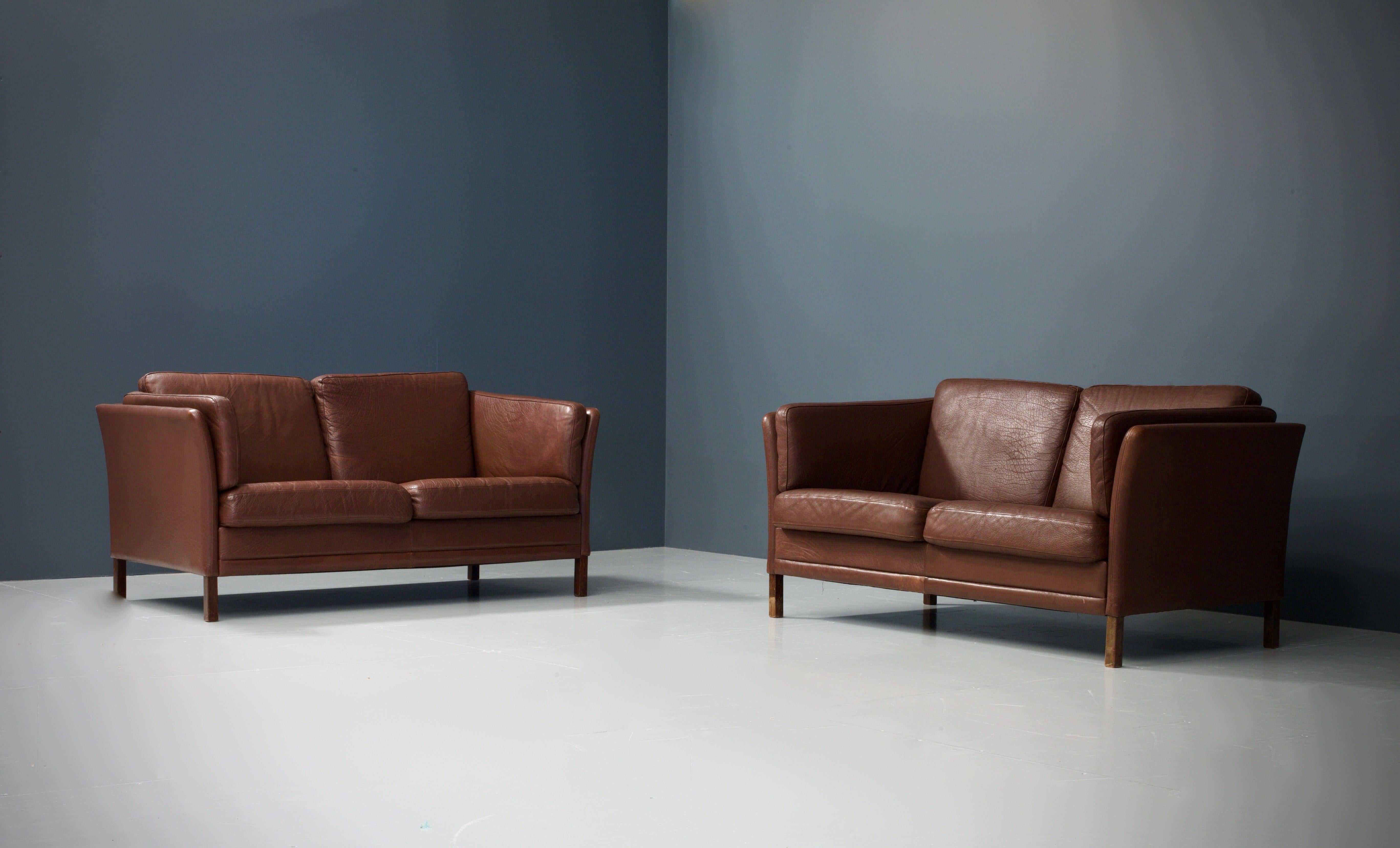These exceptional aubergine colored sofas from the sixties are made to the very high standard expected of one of Denmark's foremost furniture makers, Mogens Hansen. The design is minimalistic in shape, but you can find a lot of attention for detail,