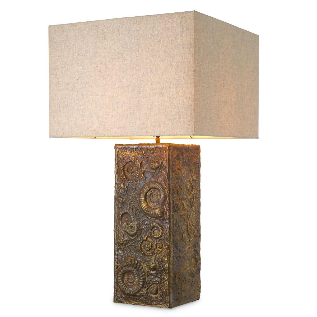 This vintage brass table lamp offers a refined blend of sculptural design and warm ambient lighting. Crafted with a hand-cast base featuring fossil-inspired detailing, the table lamp displays a textured, artistic surface that stands out in both