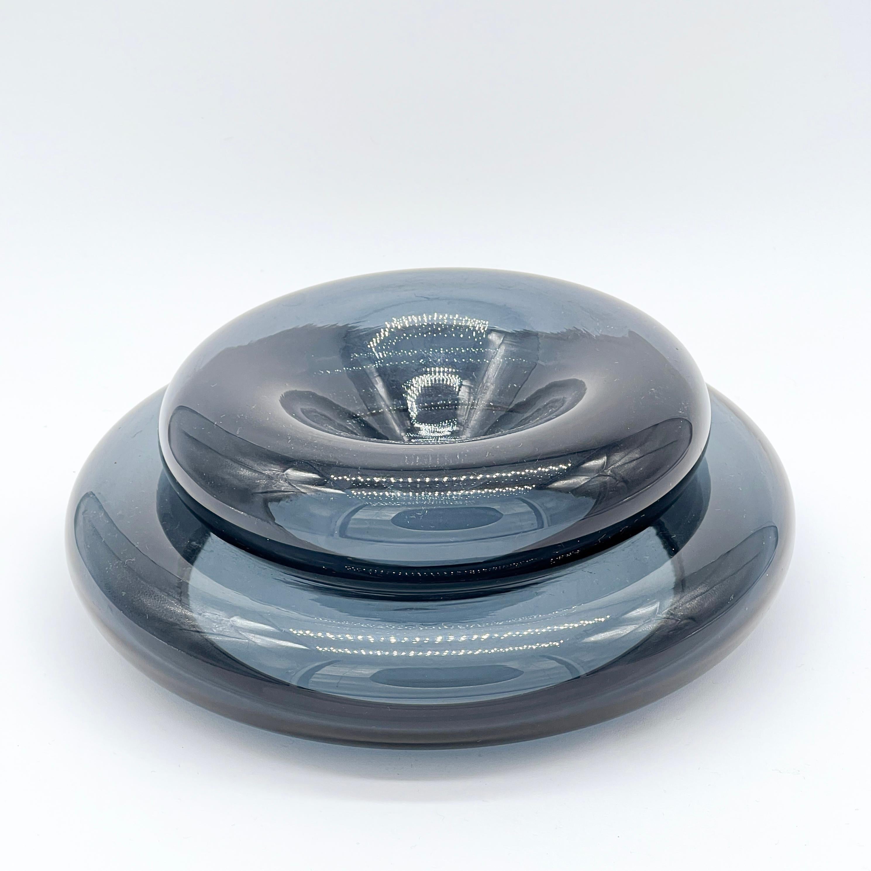 Vintage set of two stackable vide poches in blue/grey blown Murano glass, rounded and smooth. They can be used as a sculptural piece, placed one above each other, or as two separate valet trays. The bigger one measures 20cm in diameter and can