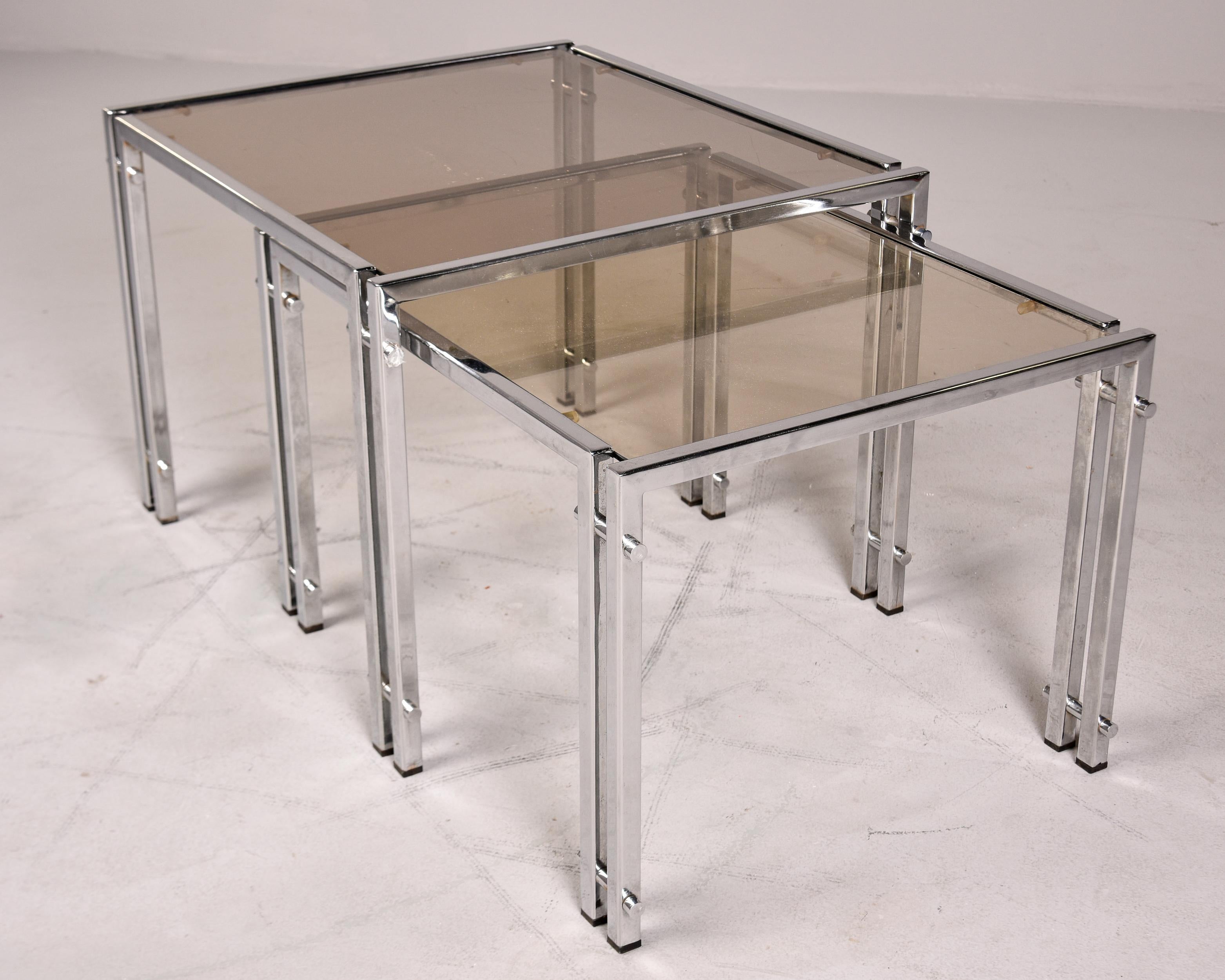 Mid-Century Modern Set of Two Vintage Nesting Tables with Chrome Frames and Pale Smoke Glass Tops For Sale