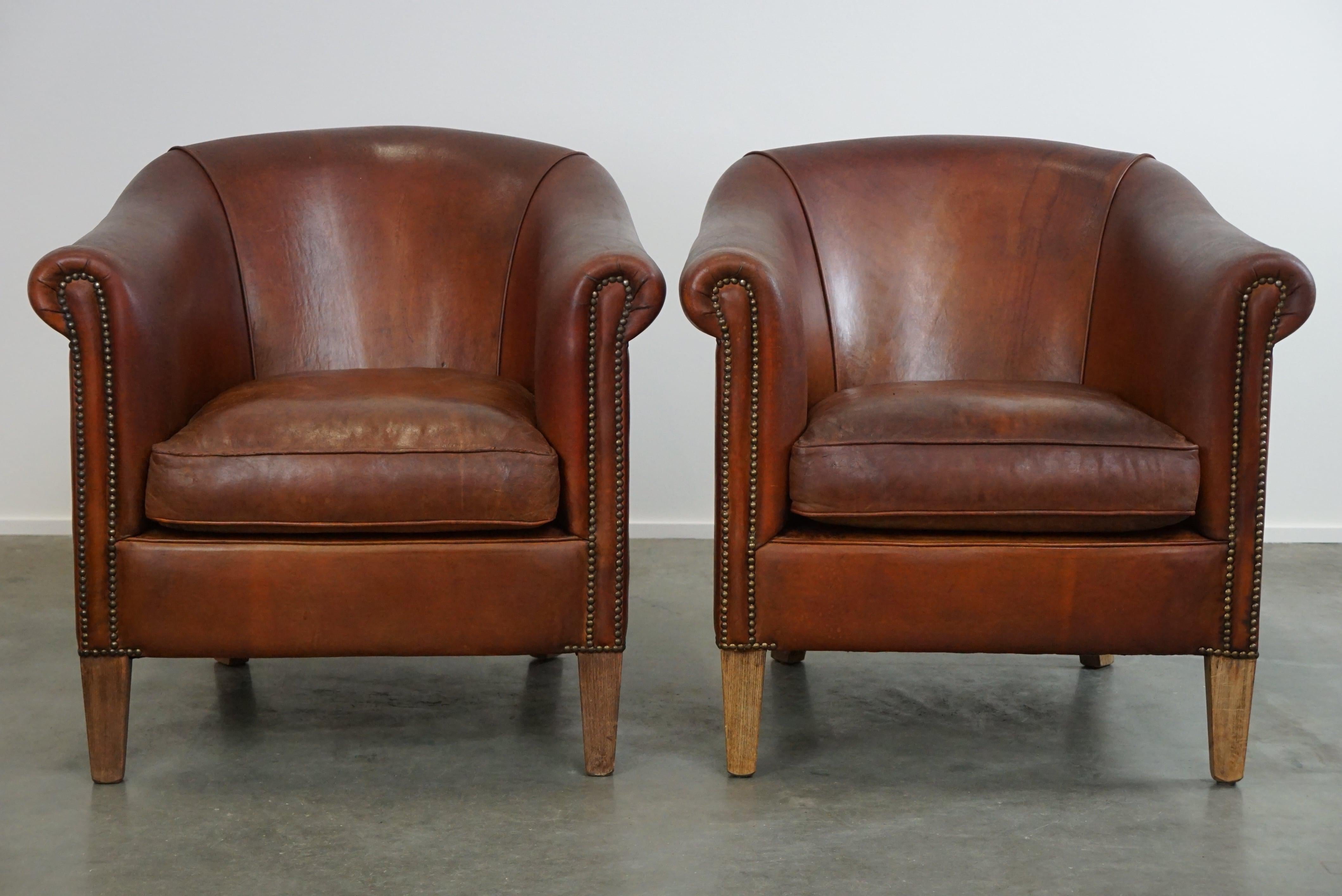 Offered: this lovely set of two vintage sheep leather club armchairs with a rugged character.

With a set of sheep leather club armchairs that have acquired a beautiful patina through use, you're purchasing something that fits into any style and is