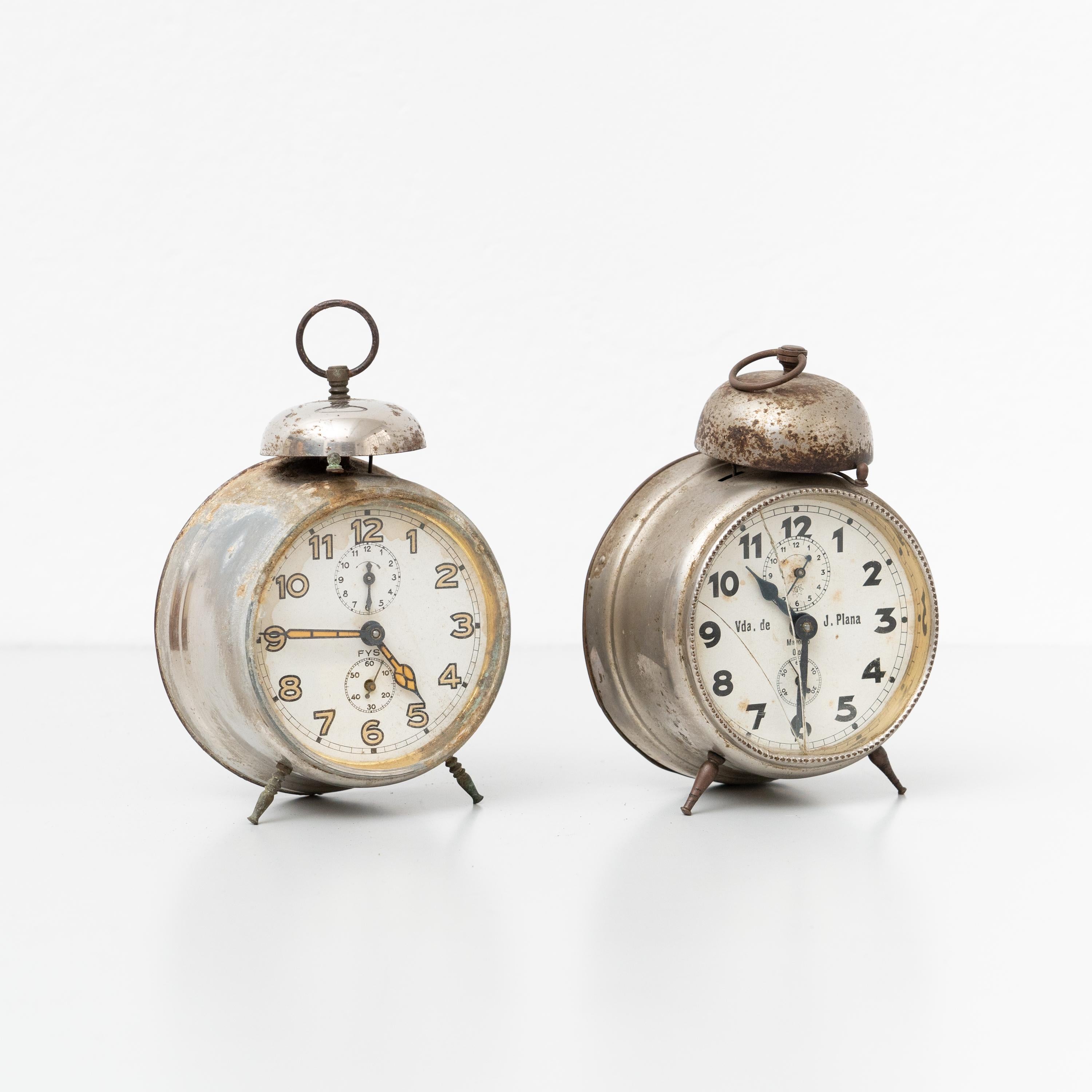 Set of Two vintage Spanish traditional alarm clocks.

Manufactured by unknown company in Spain, circa 1960.

In original condition with minor wear consistent of age and use, preserving a beautiful patina.

Materials:
Metal.